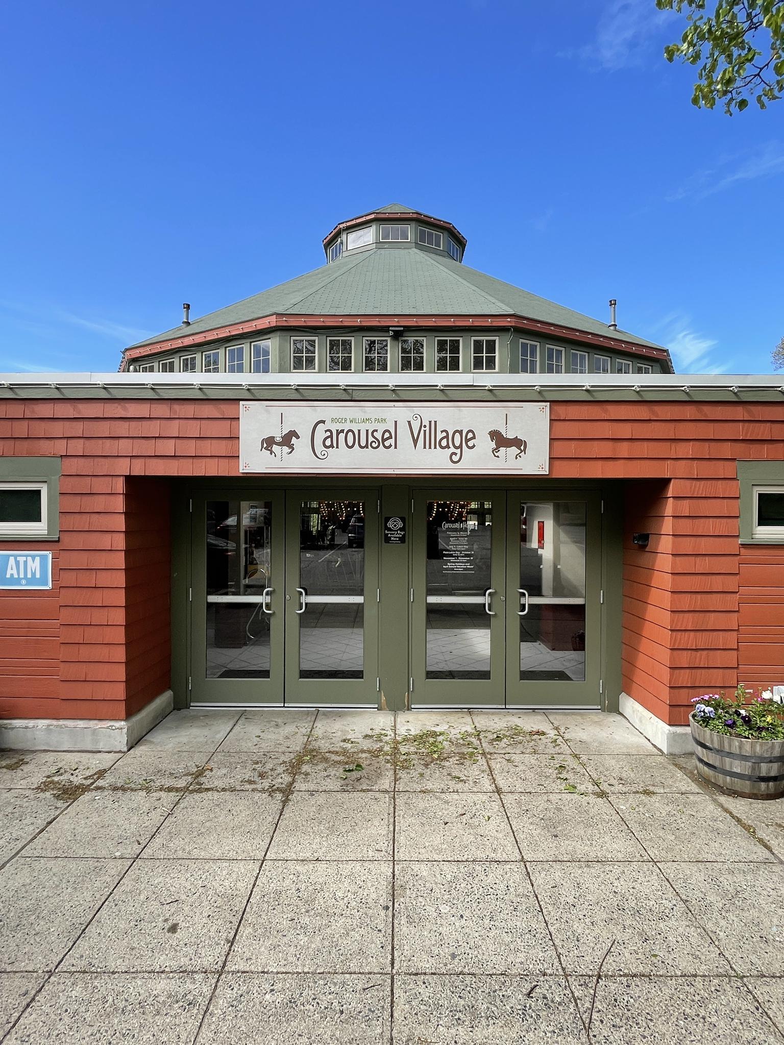 The front entrance of a building with a sign under a clear blue sky.