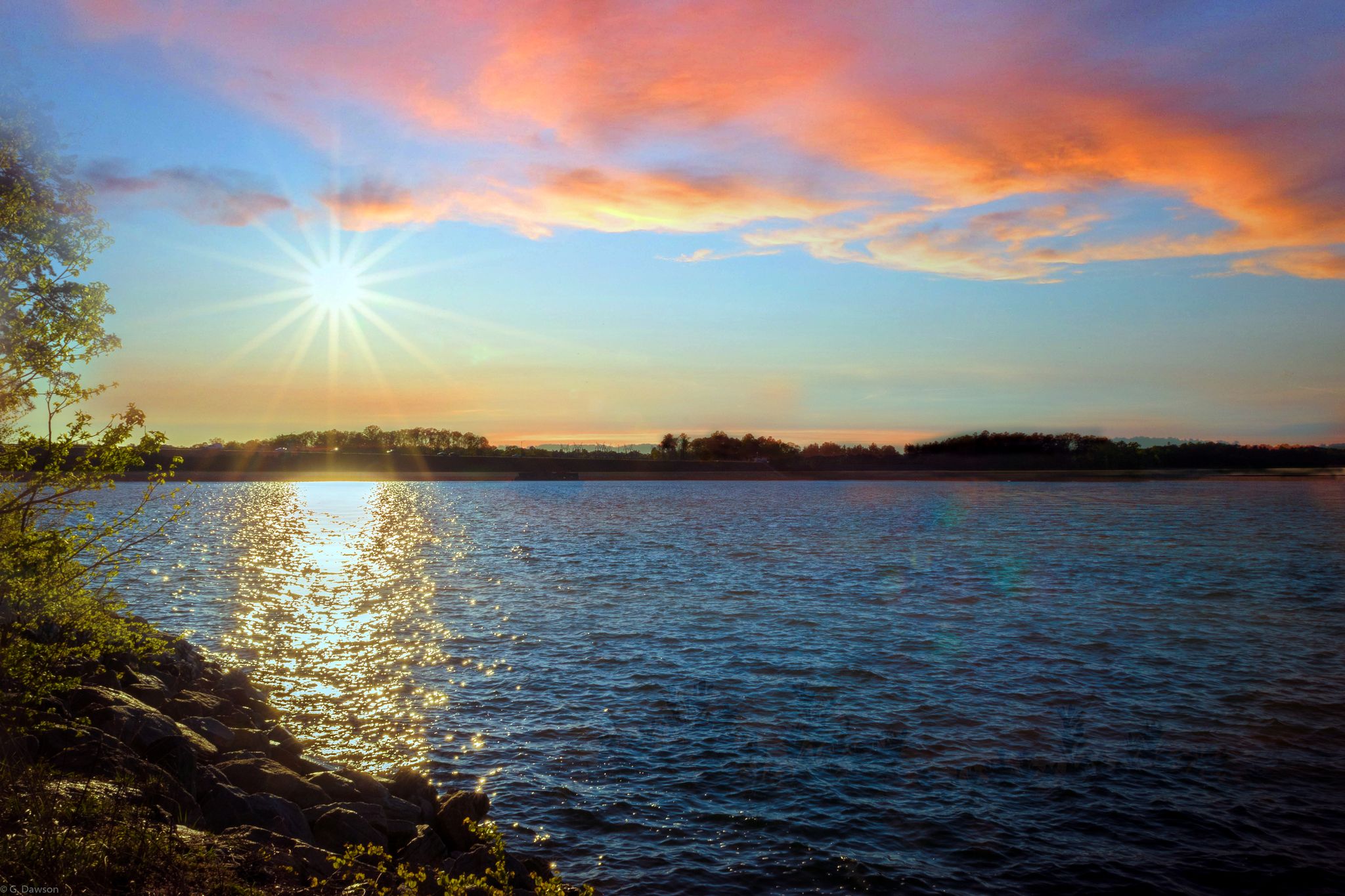 Vibrant sunset over a lake with sun reflecting on the water. - Laurel Ridge Trail loop