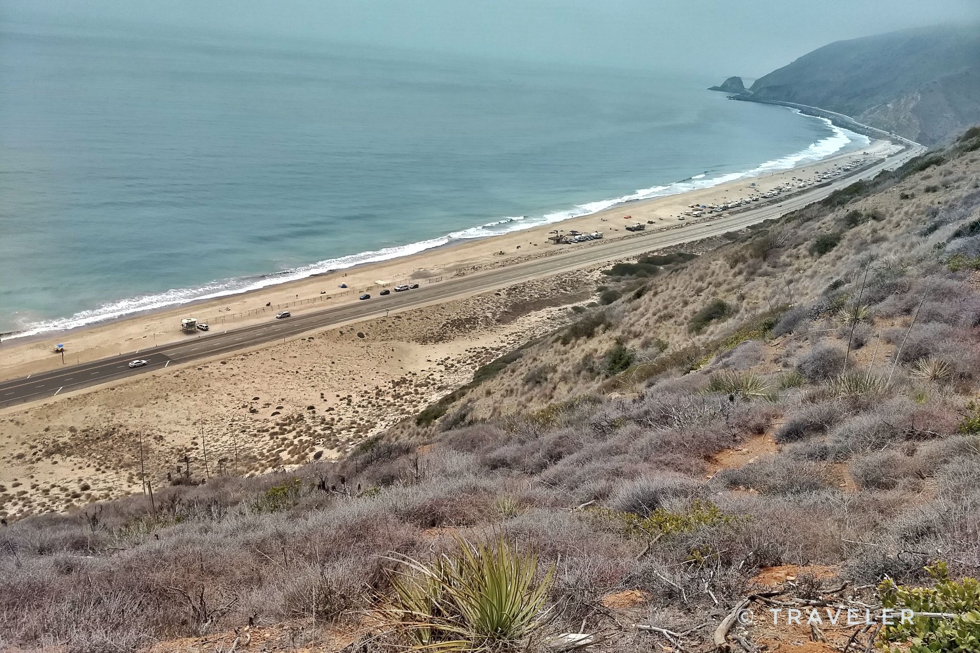 Overcast view of a coastal highway beside a sandy beach and ocean. - Ray Miller and Overlook Trail Loop