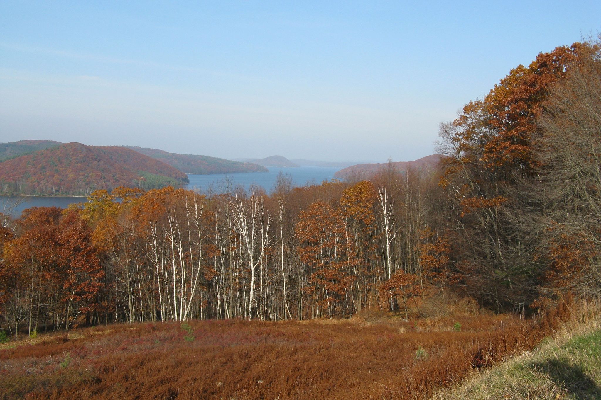 Autumn landscape with a lake, hills, and colorful trees under a clear sky. - Around the Quabbin Reservoir
