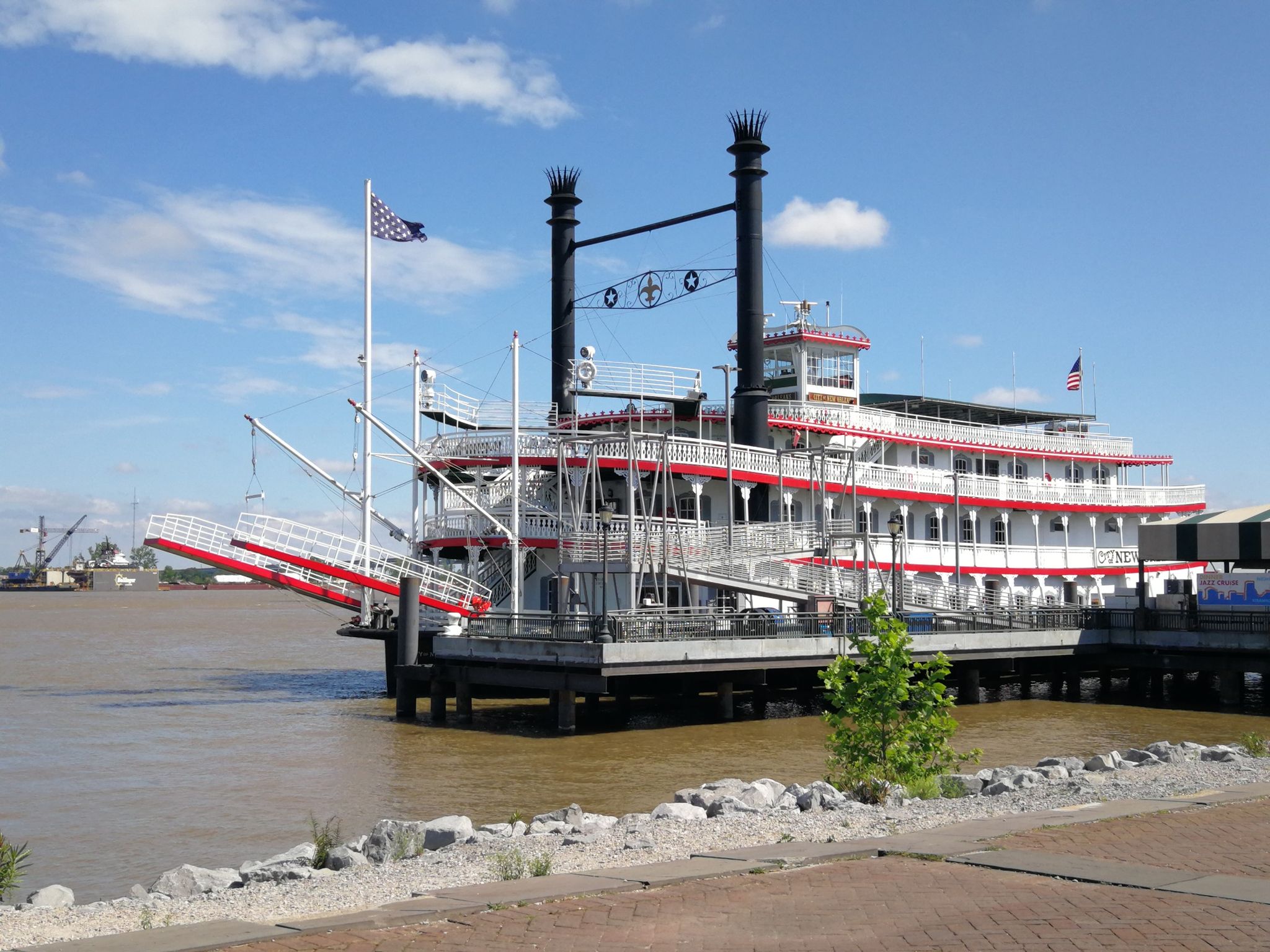 A large paddlewheel boat docked at a pier on a sunny day. - Steamboat Natchez – Washington Artillery Park loop from New Orleans