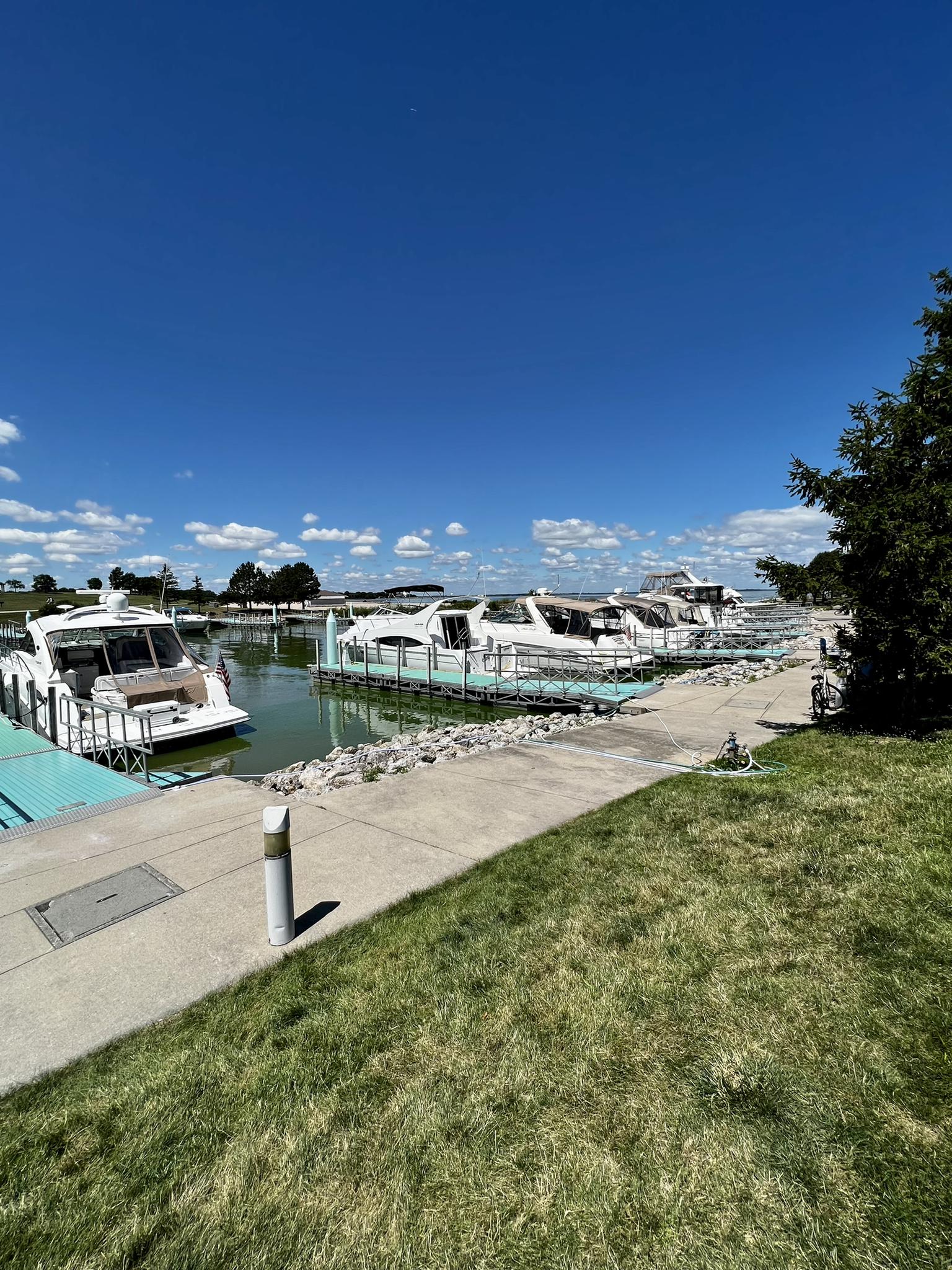Several boats docked in a marina on a bright sunny day.