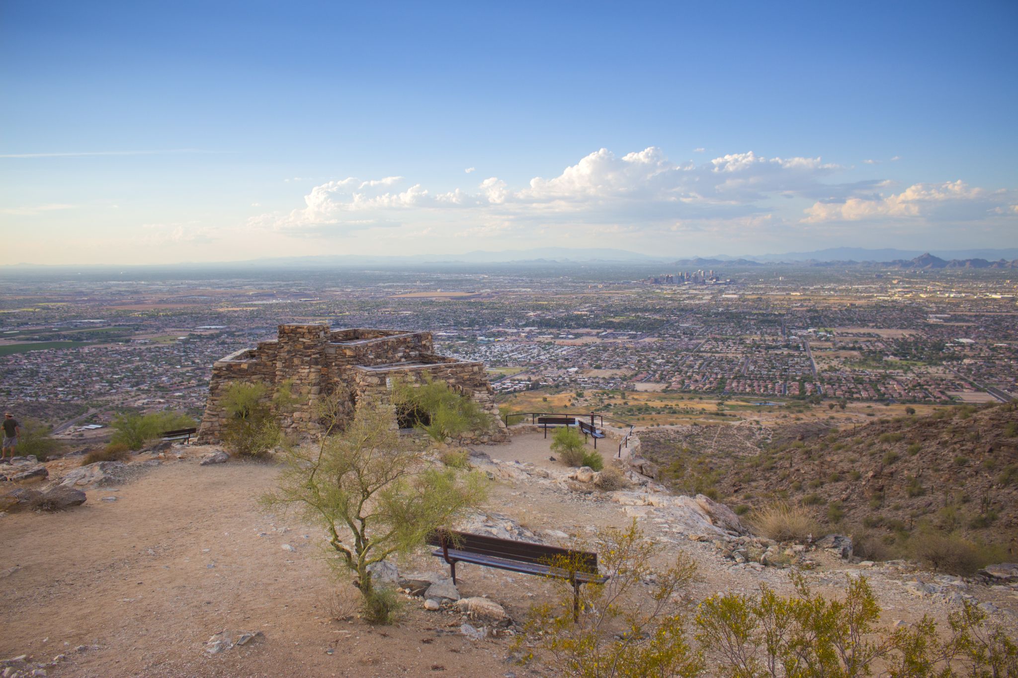 Stone structure on a desert hilltop overlooking a vast city at dusk. - National and Maricopa Trail Loop