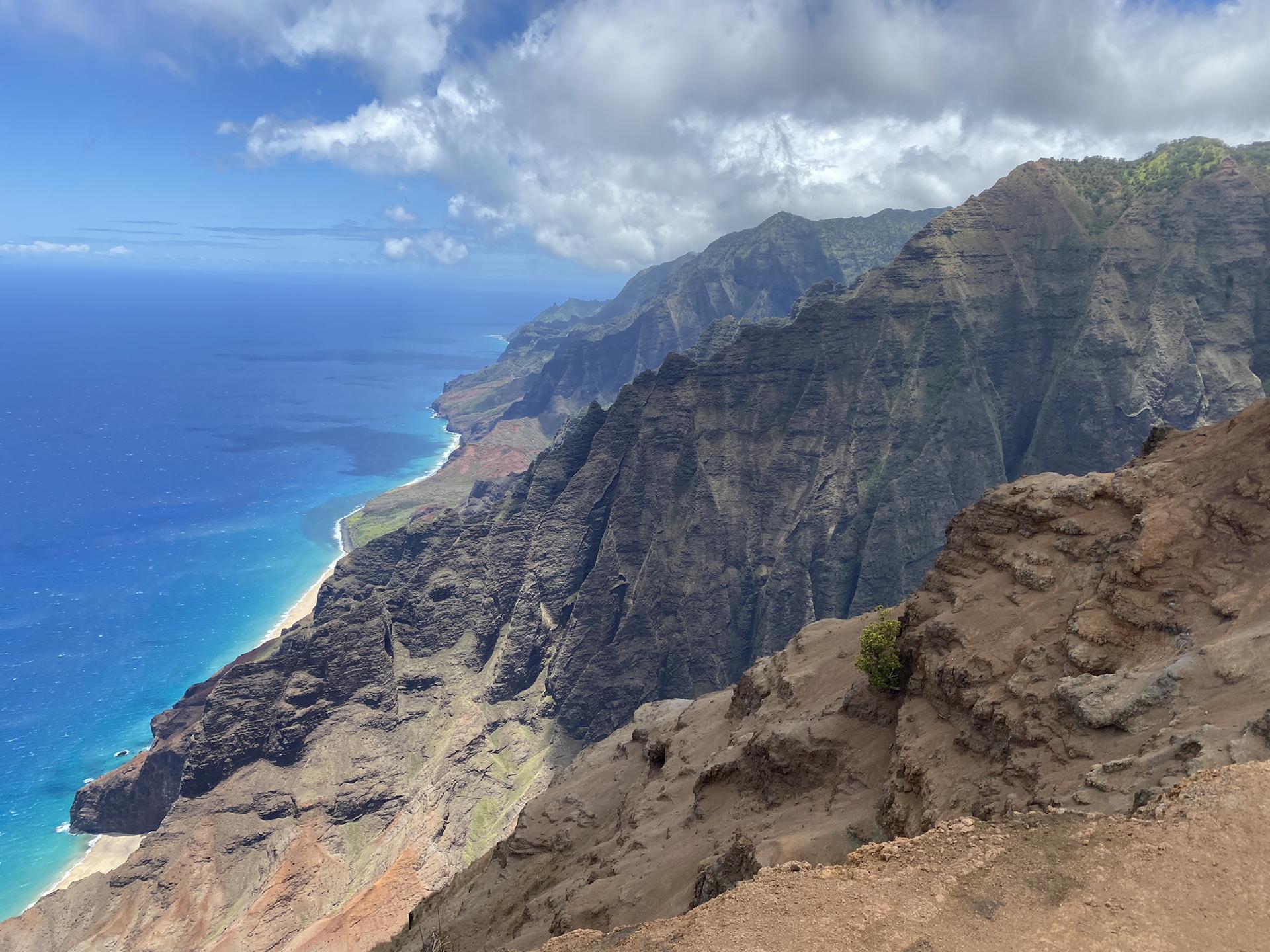 Panoramic view of rugged coastal cliffs meeting a vibrant blue ocean.