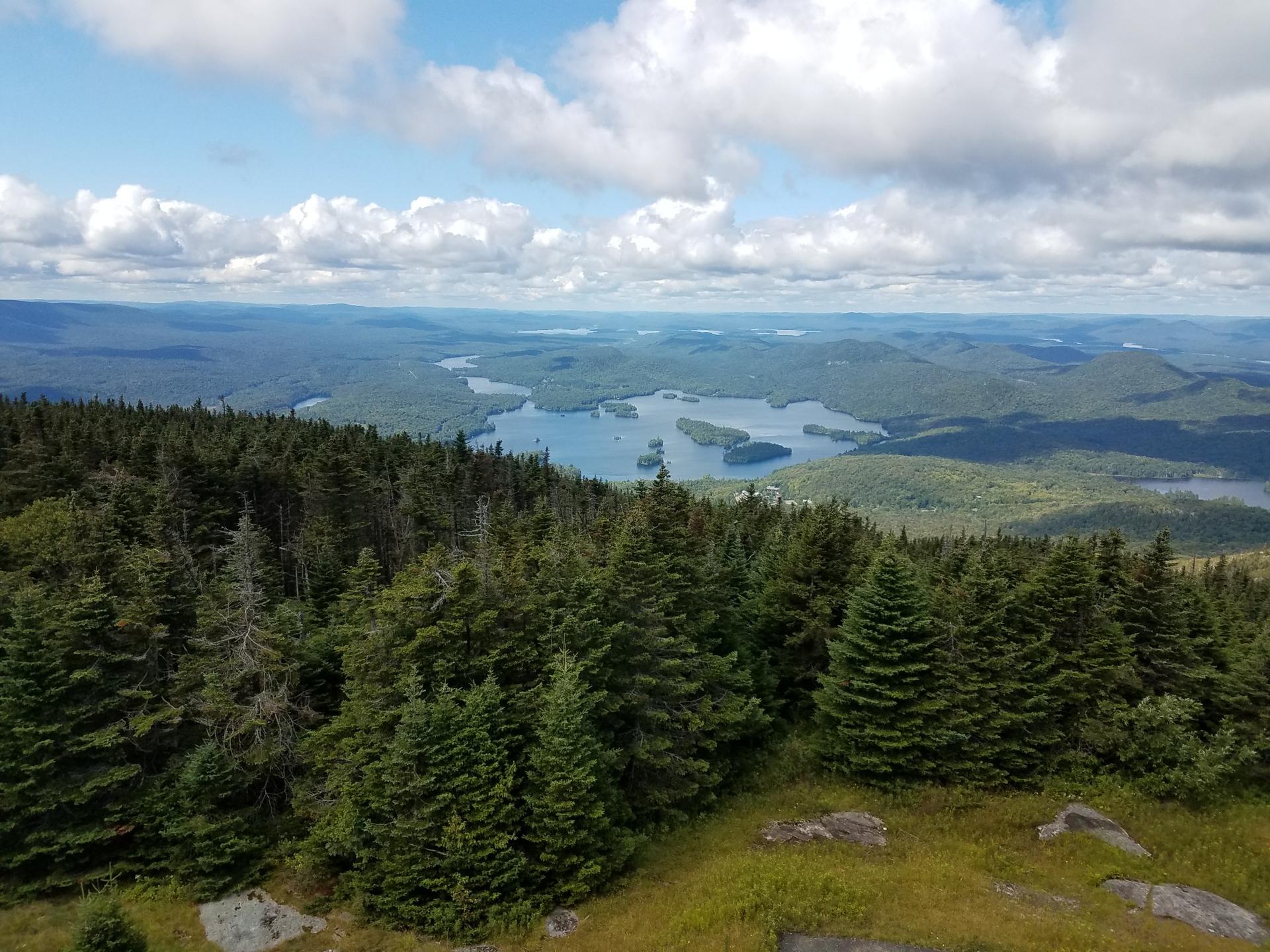 Vast mountain vista with a large lake and islands, sunny day.