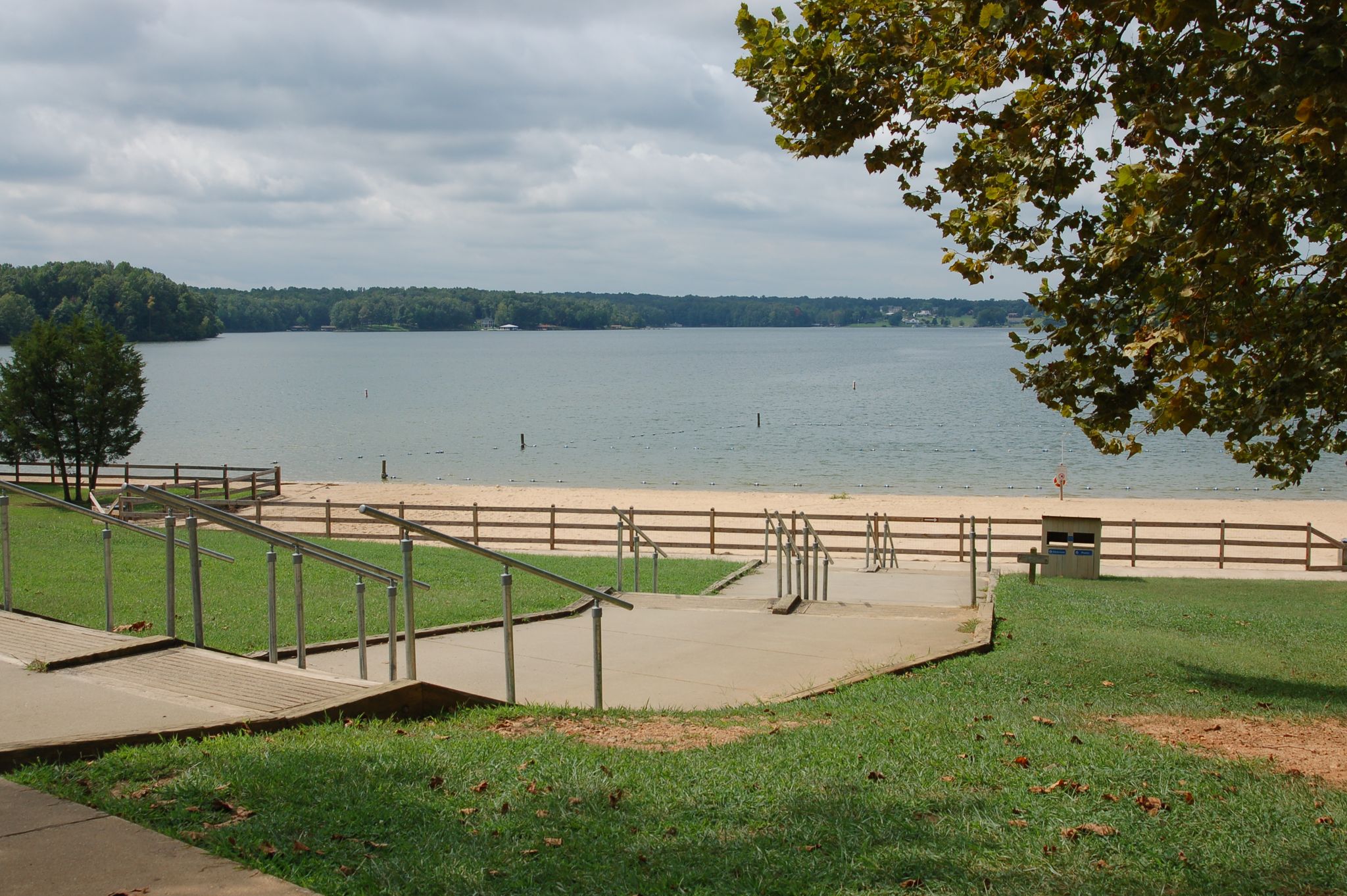 A sandy beach and lake with steps and a fence under an overcast sky. - Lake Anna loop from Bumpass