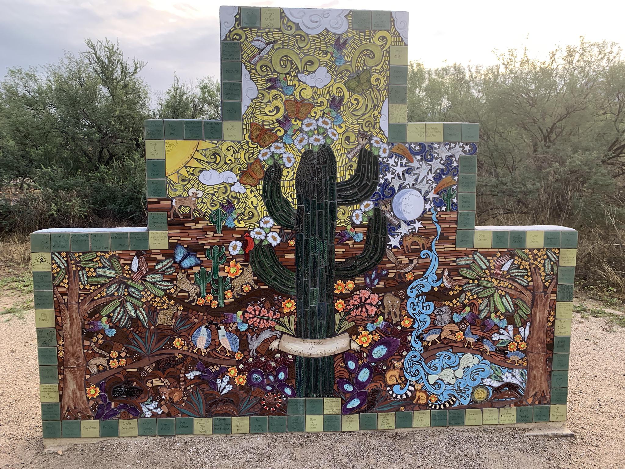 Colorful tiled mural depicting a saguaro cactus, desert plants, and animals.