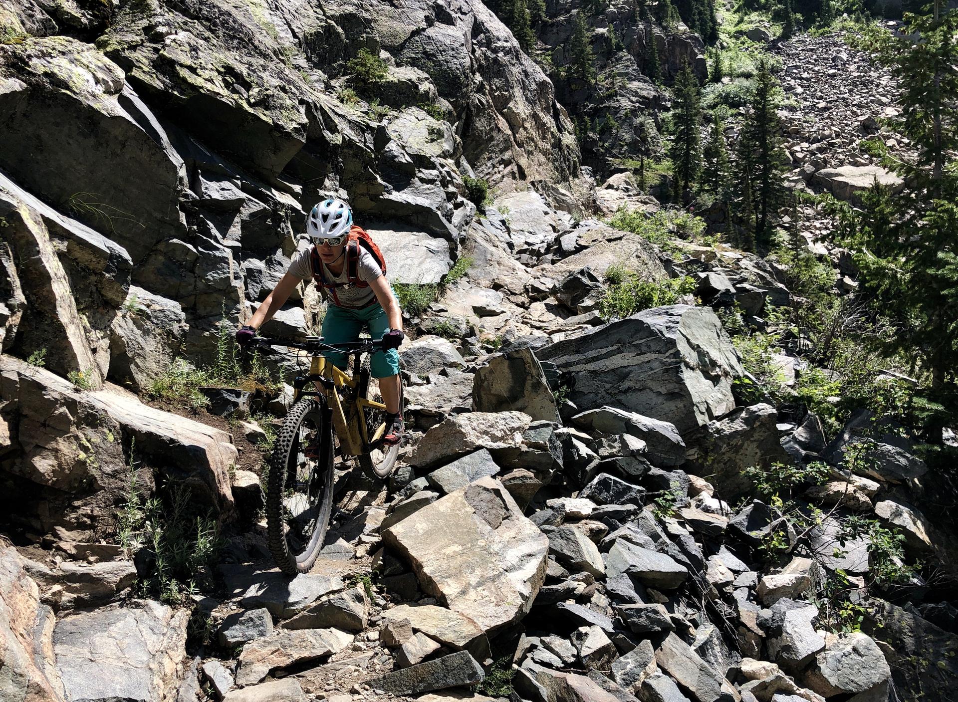 Person on a mountain bike navigating a rocky trail.