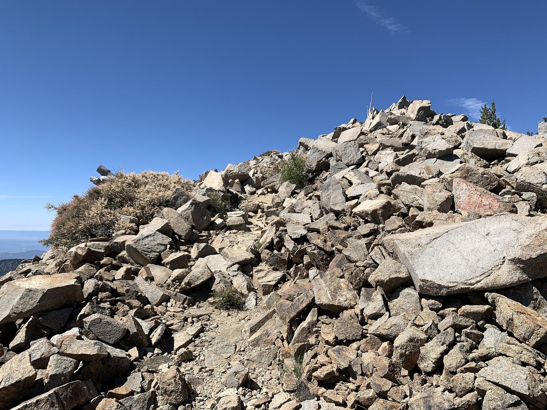 Jagged rocky mountain peak under a bright clear blue sky.