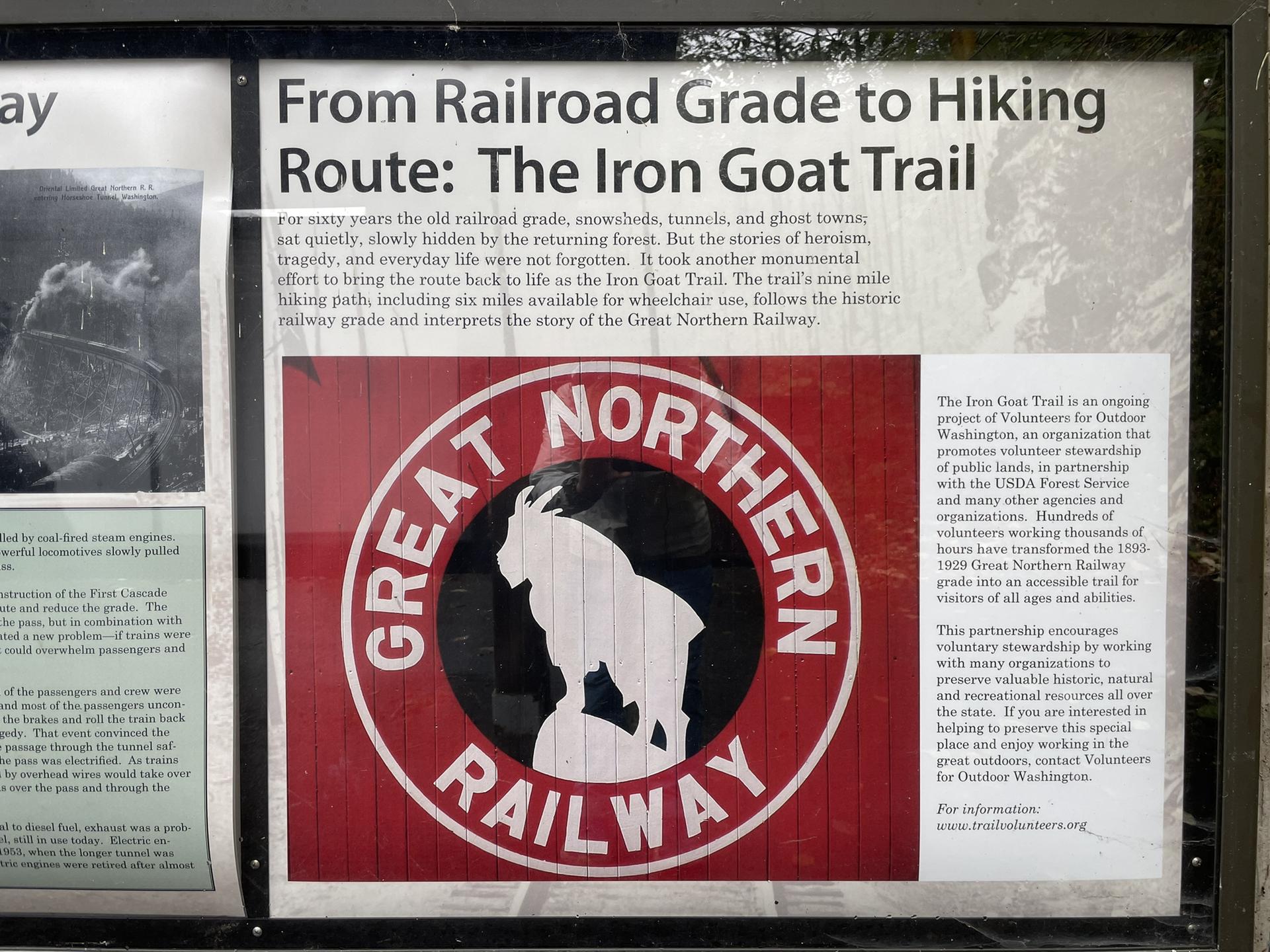 Informational sign with text about a hiking route and a red goat railway logo.
