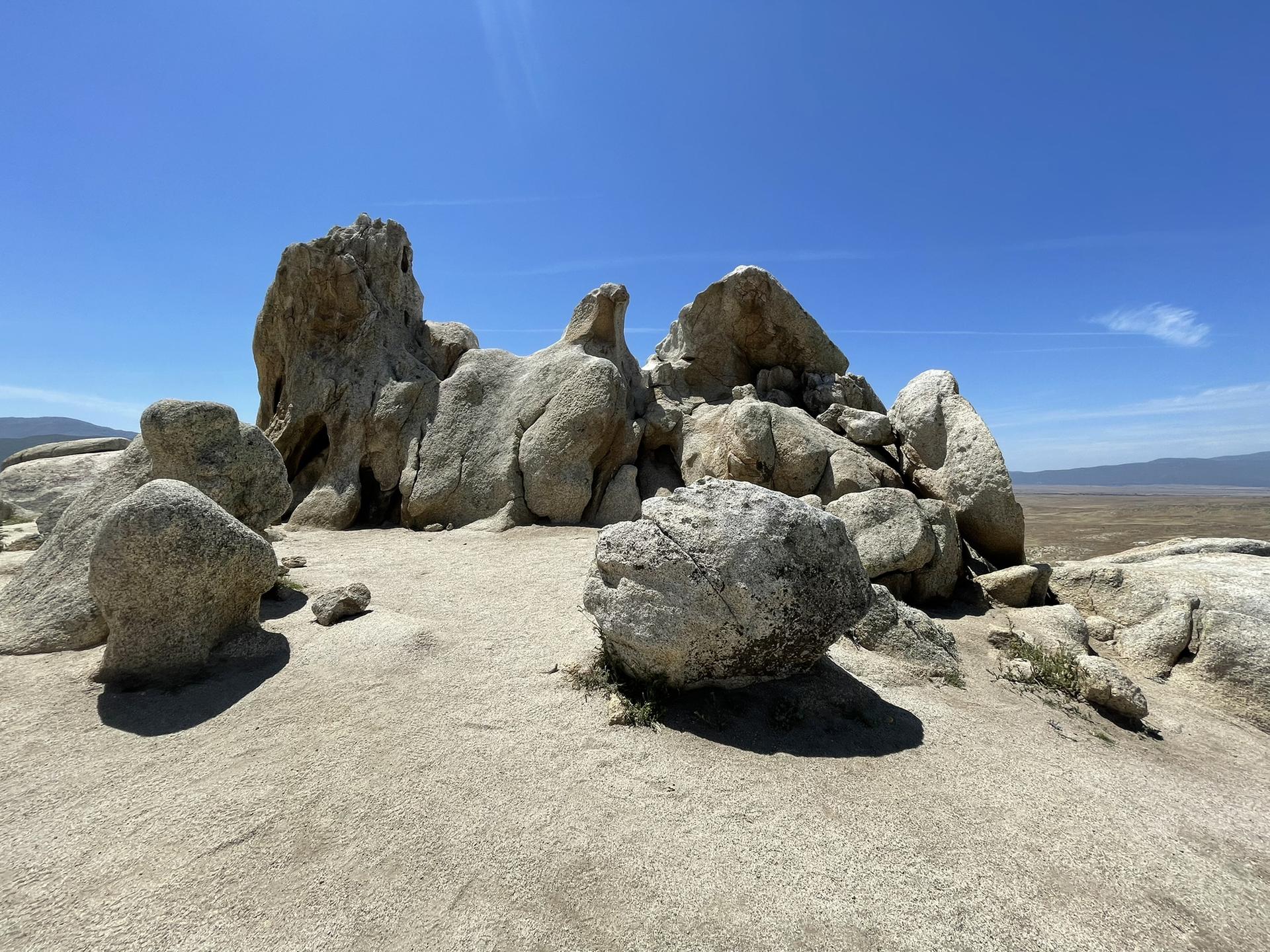 Large, light-colored rock formations on a sunny day with a clear blue sky.
