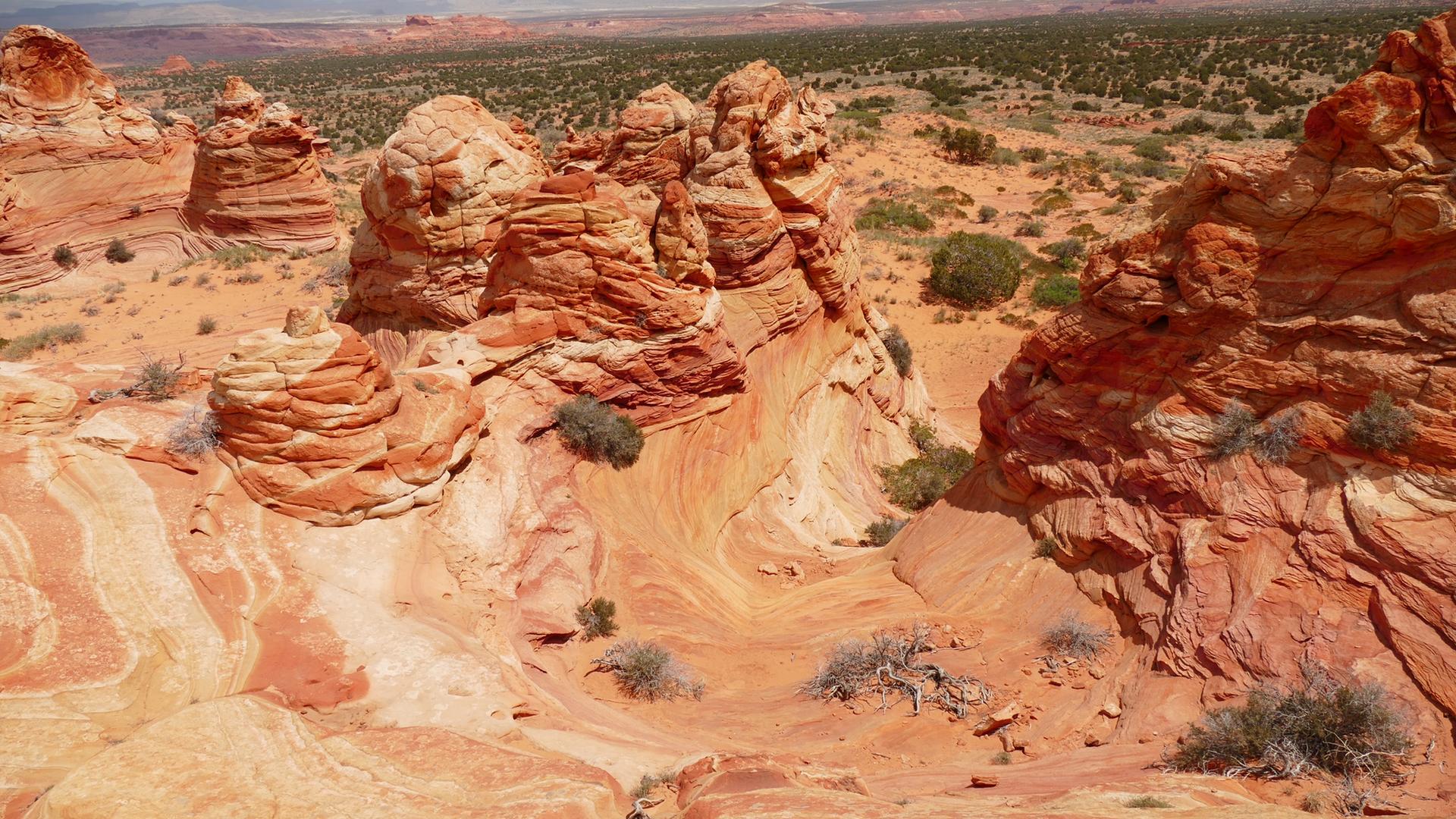 Vibrant red and orange layered rock formations create a swirling desert canyon.