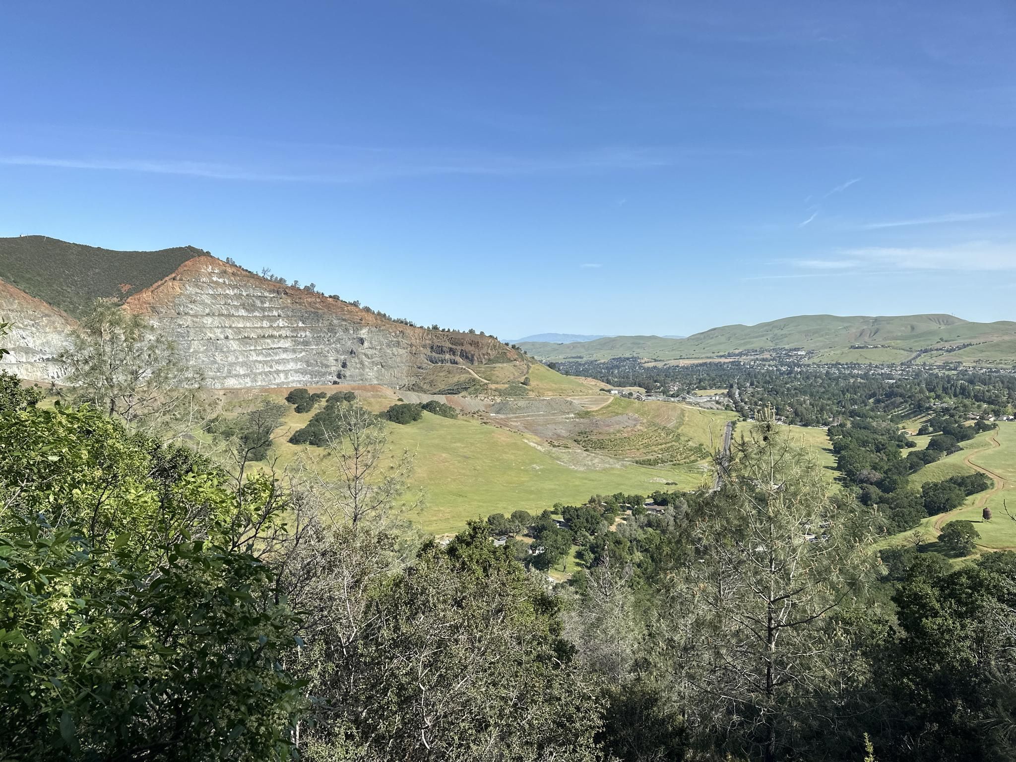 Green valley and forested hills with a terraced mountain under a clear blue sky. - Mitchell Canyon and Eagle Peak Loop