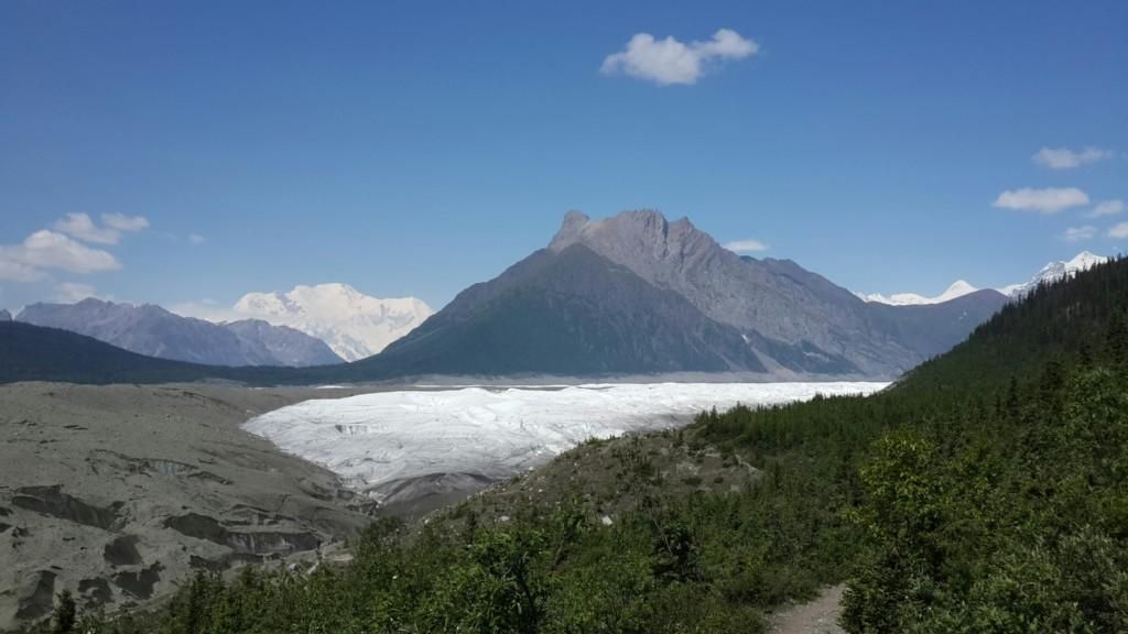 A wide glacier in a valley, surrounded by mountains on a sunny day. - View of Root Glacier – View of Root Glacier loop from Glacier View 2025