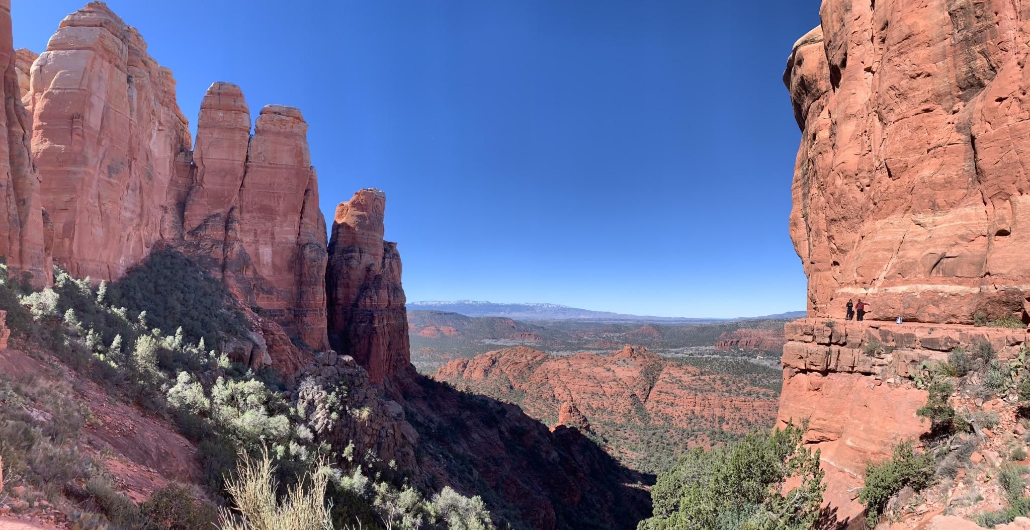 Panoramic view of towering red rock formations under a clear blue sky. - Cathedral Rock Trail