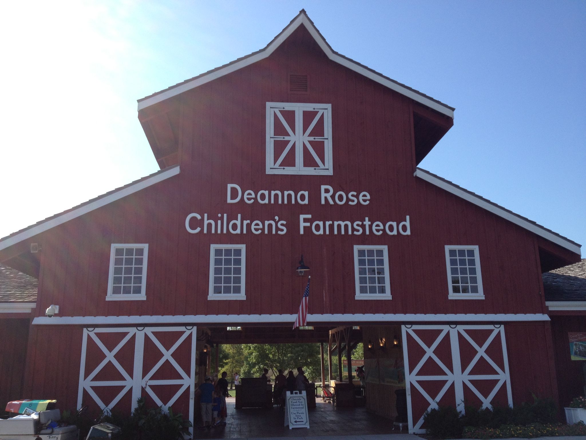 Large red barn with white trim and text under a bright, clear sky. - Amesbury Lake Park – Tomahawk Creek loop from Church of the Resurrection
