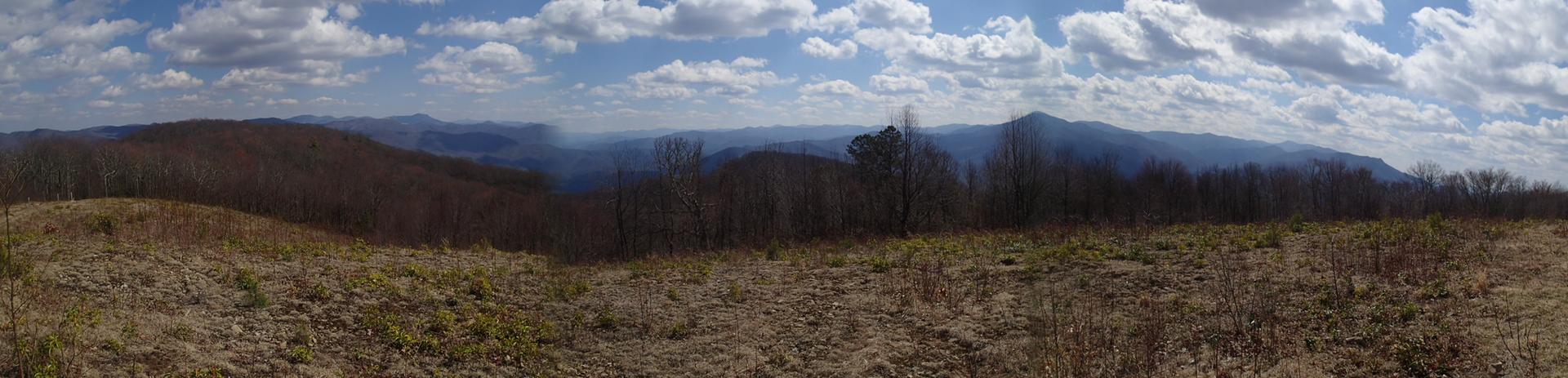 Panoramic view of distant hazy mountains under a cloudy sky.
