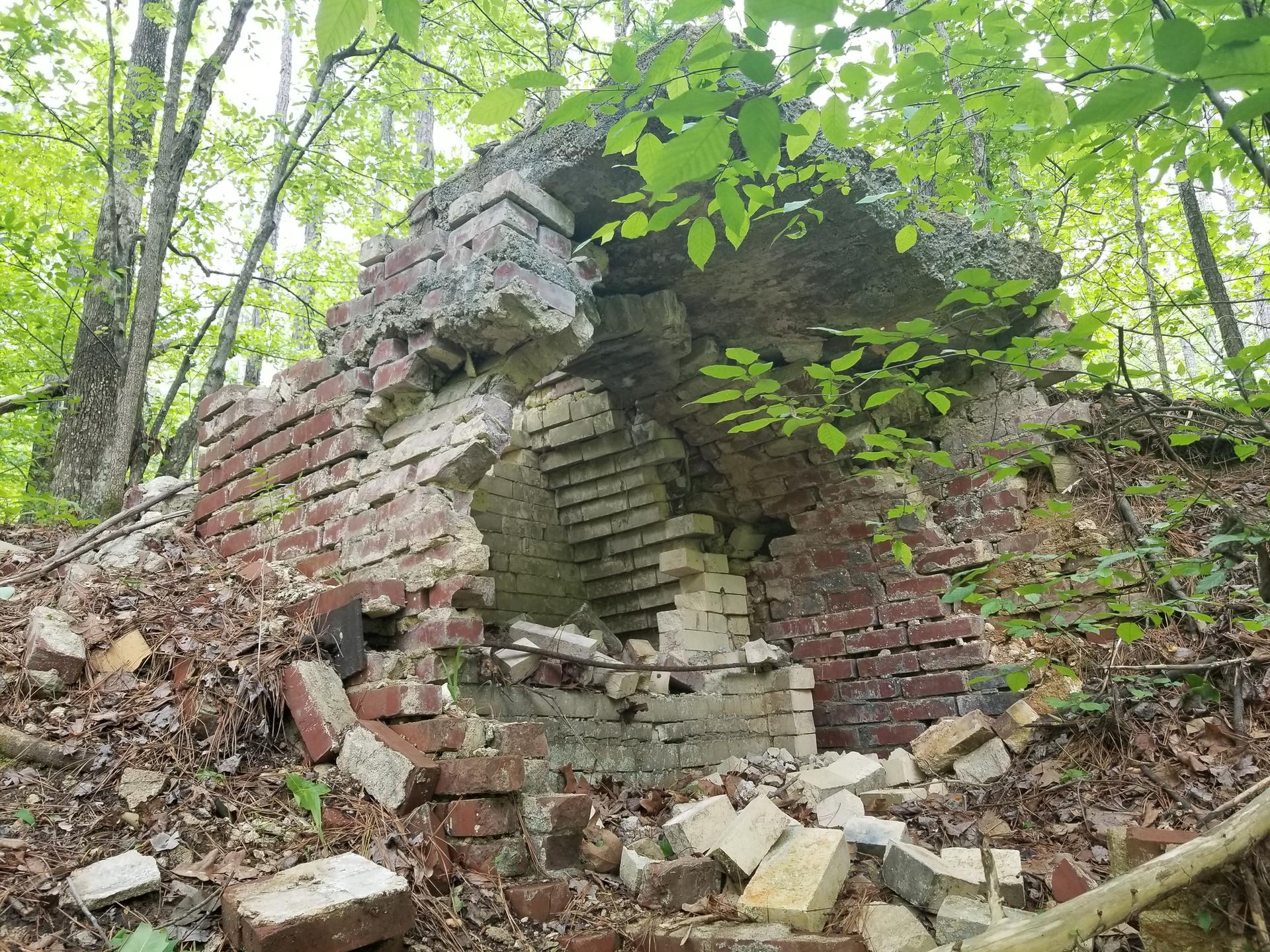 Crumbling brick and concrete ruins in a bright, green forest.
