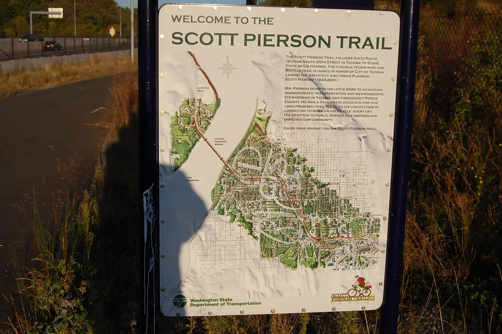 Information sign with a map, casting a person's shadow on a sunny day.