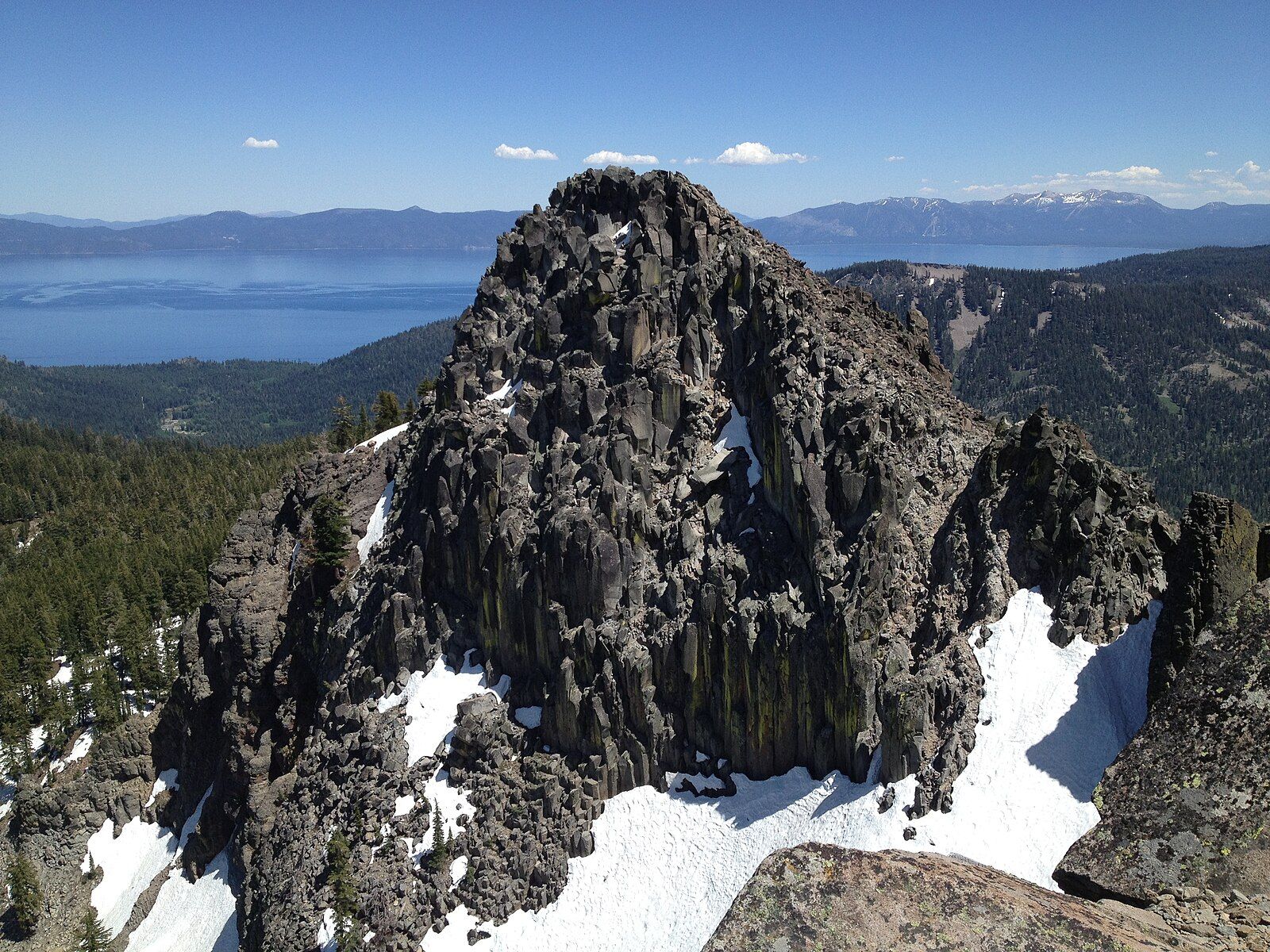 Rugged rocky peak with patches of snow under a clear blue sky. - Tahoe Rim Trail to Twin Peaks