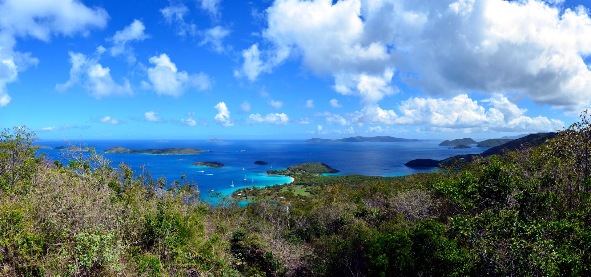 Panoramic view of a vibrant blue ocean dotted with islands and boats.
