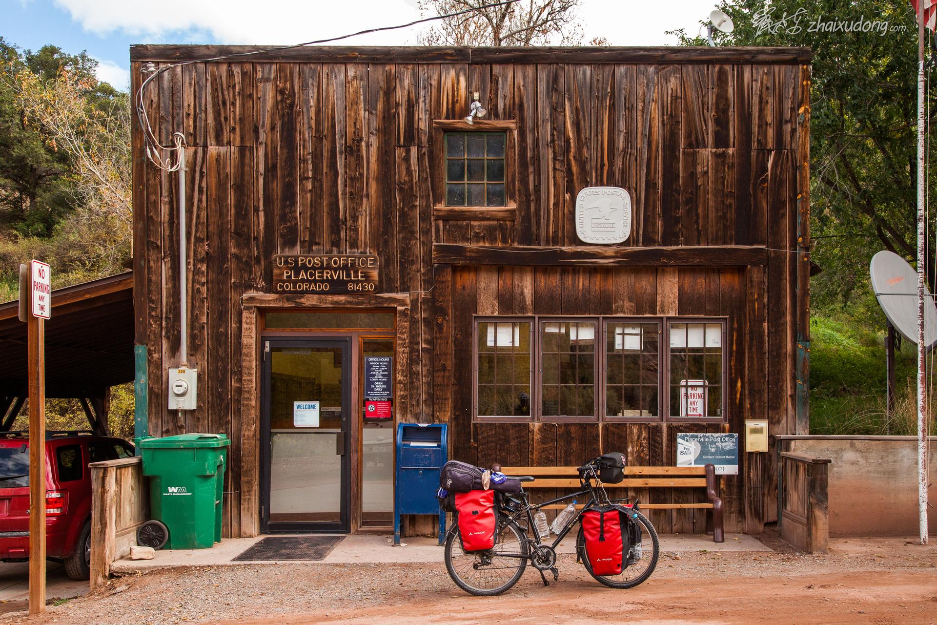 Rustic wooden building with a bicycle parked outside under diffused light.