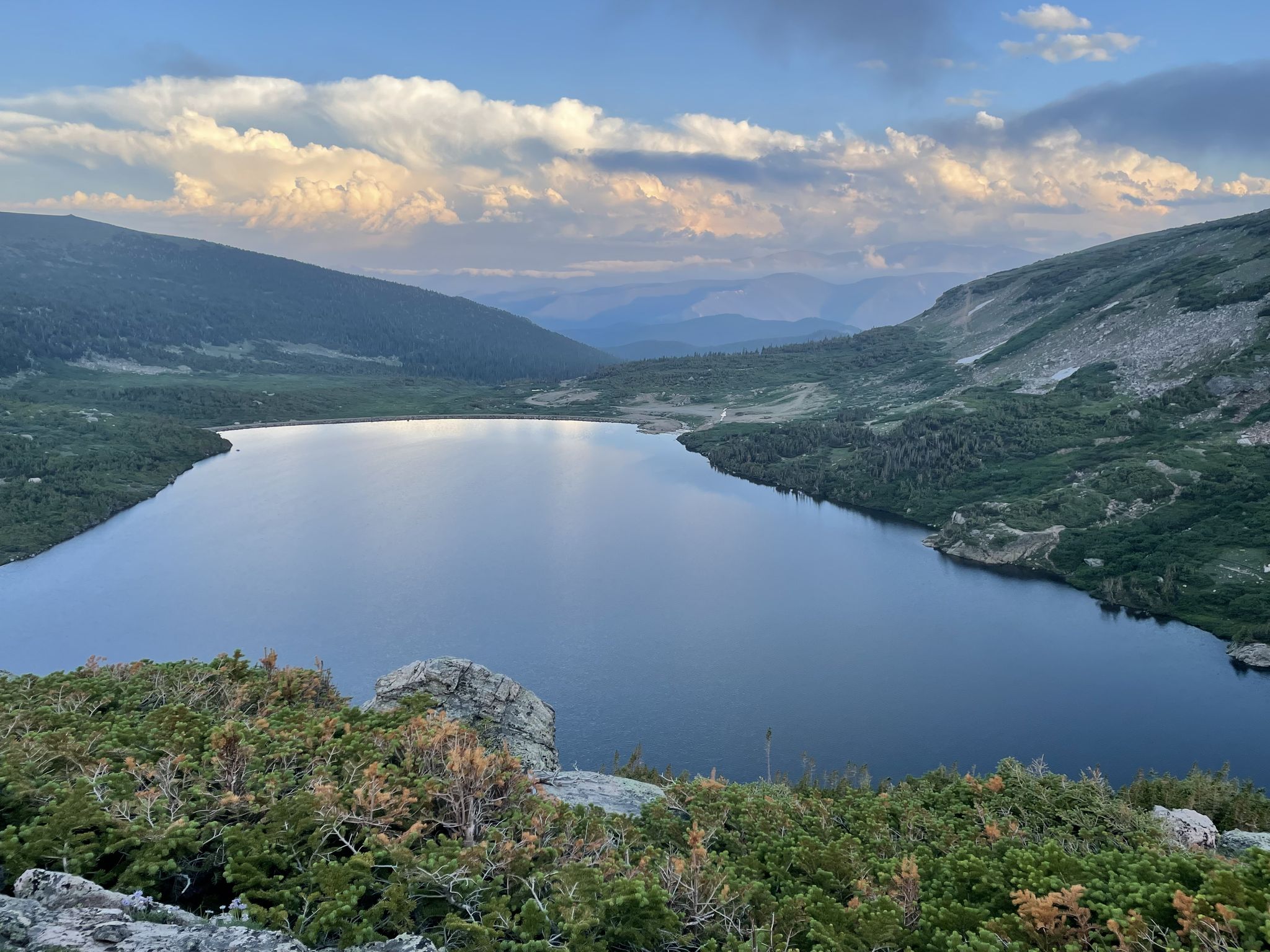 A serene mountain lake surrounded by green slopes under a cloudy sky. - Loch Lomond & Upper Lakes Trail loop