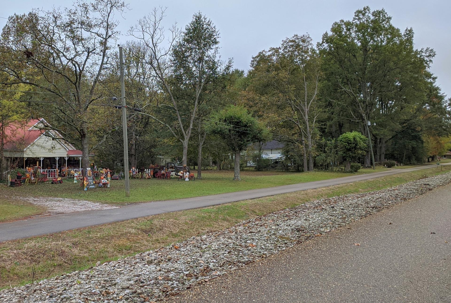 A decorated house and yard next to a paved road under an overcast sky.