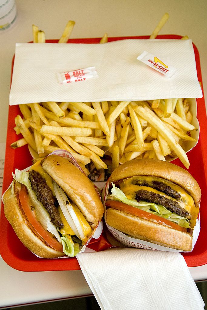 Two cheeseburgers and a large order of french fries on a red tray. - Surprise City loop