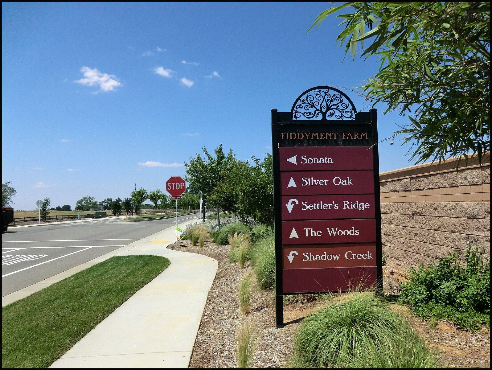 A directional sign next to a road and sidewalk under a bright blue sky. - Coyote Creek Preserve loop from Kaseberg Nature Preserve