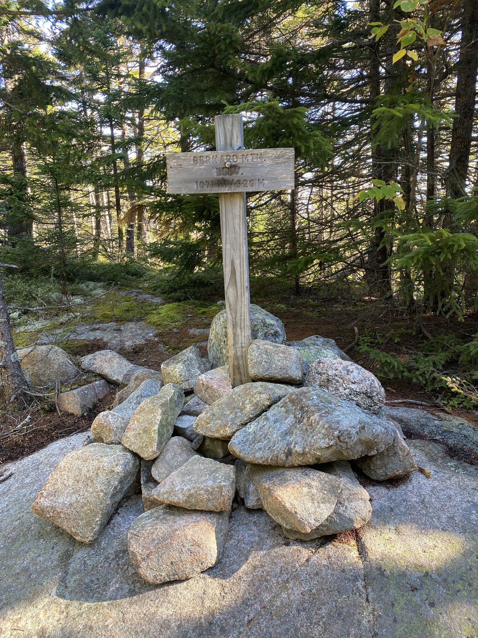 Wooden sign on a rock cairn surrounded by green forest, sunny. - Great Pond, Great Notch, Bernard Mountain, and Cold Brook Trail Loop