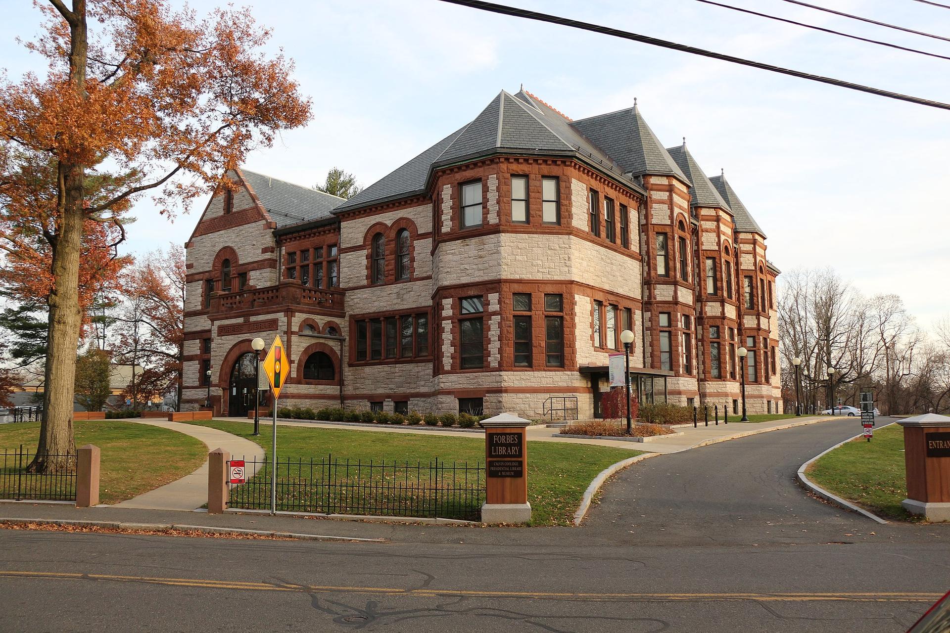 Ornate brick and stone building with a complex roof on a cloudy day.