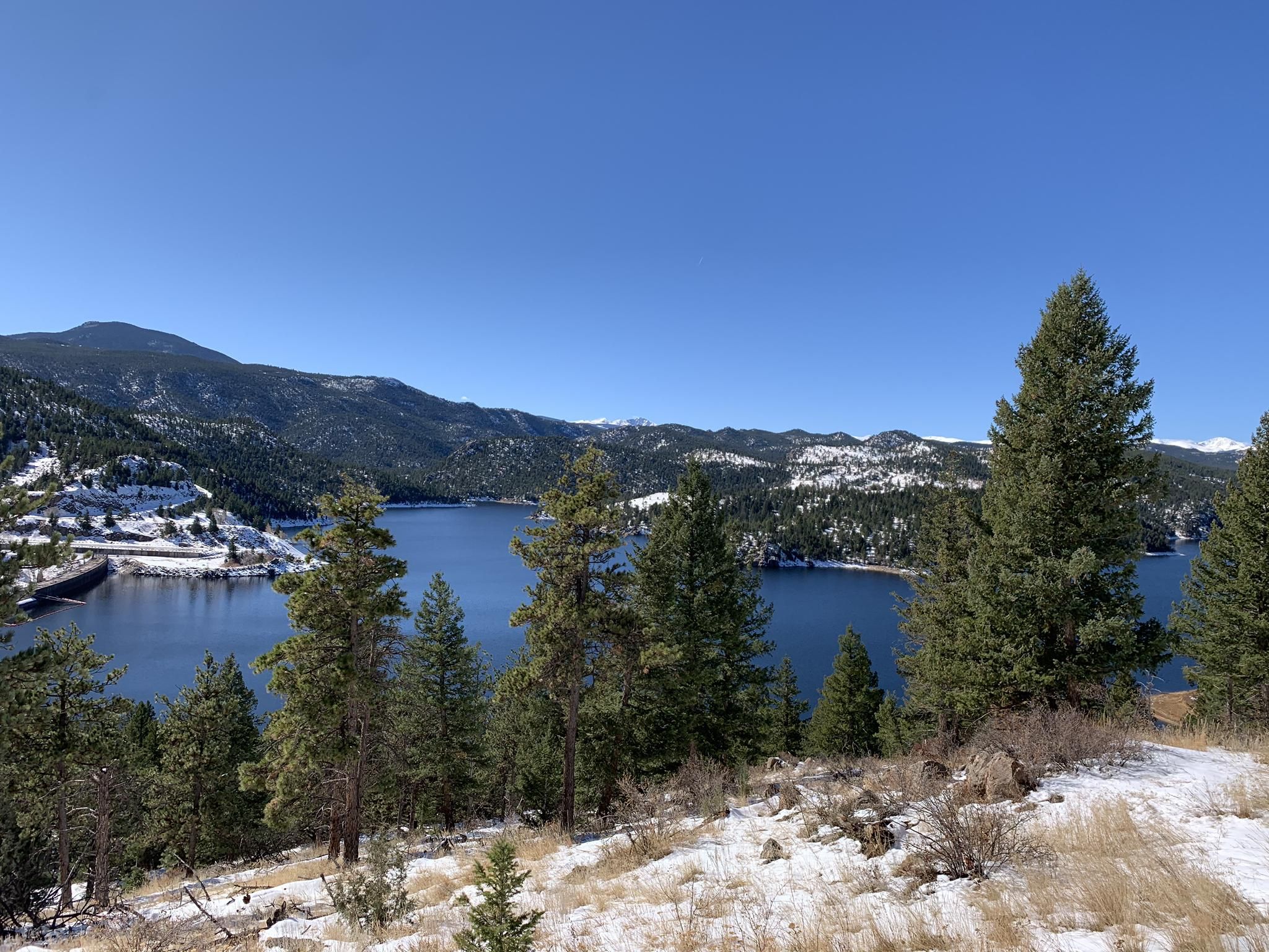 A serene lake surrounded by snow-dusted hills and evergreen trees. - Gross Reservoir – Walker Ranch Loop Trailhead loop from First Baptist Church