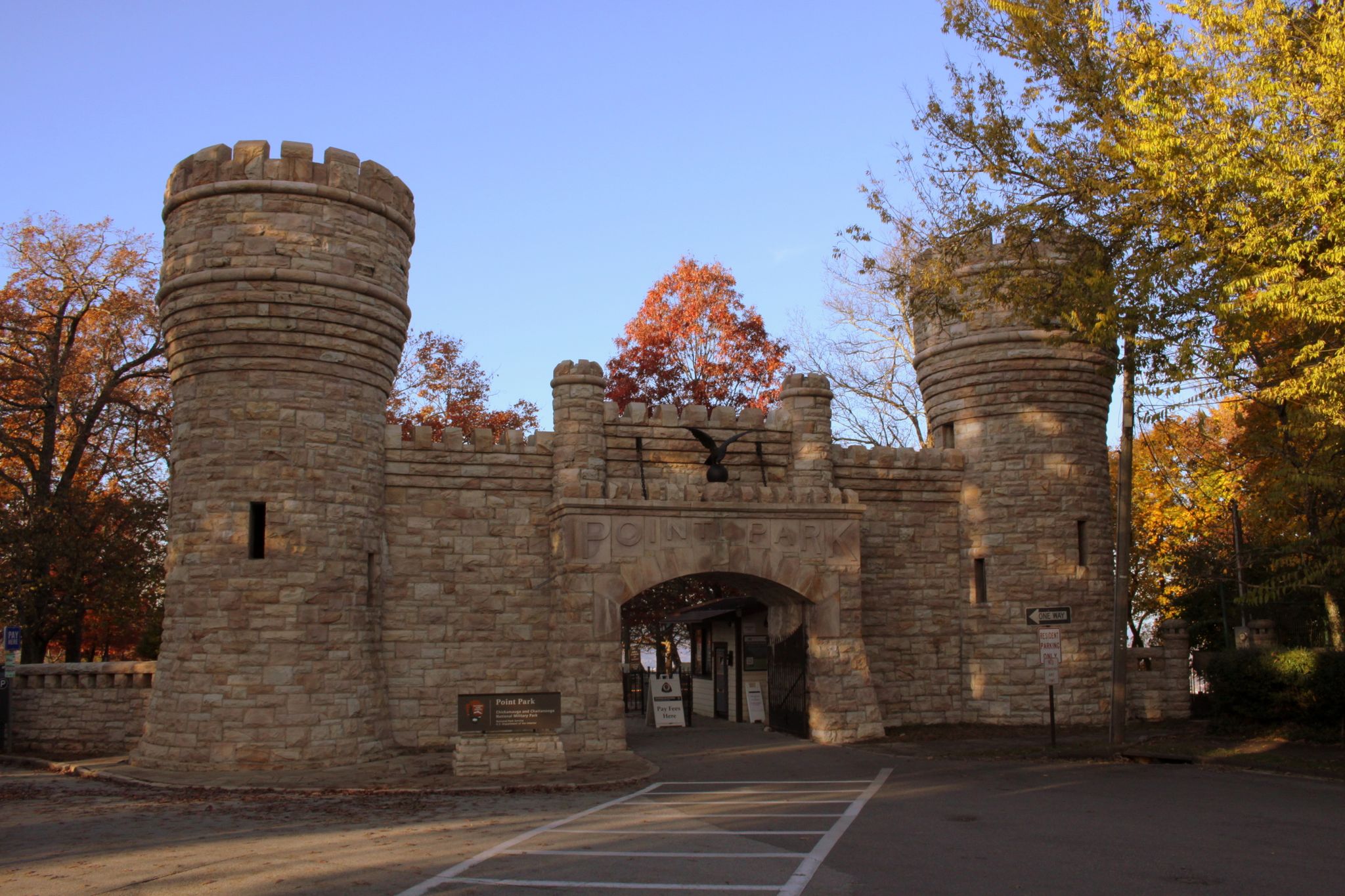 Stone castle-like gate with two towers and archway, surrounded by autumn trees. - Guild and Lookout Mountain Trails Loop