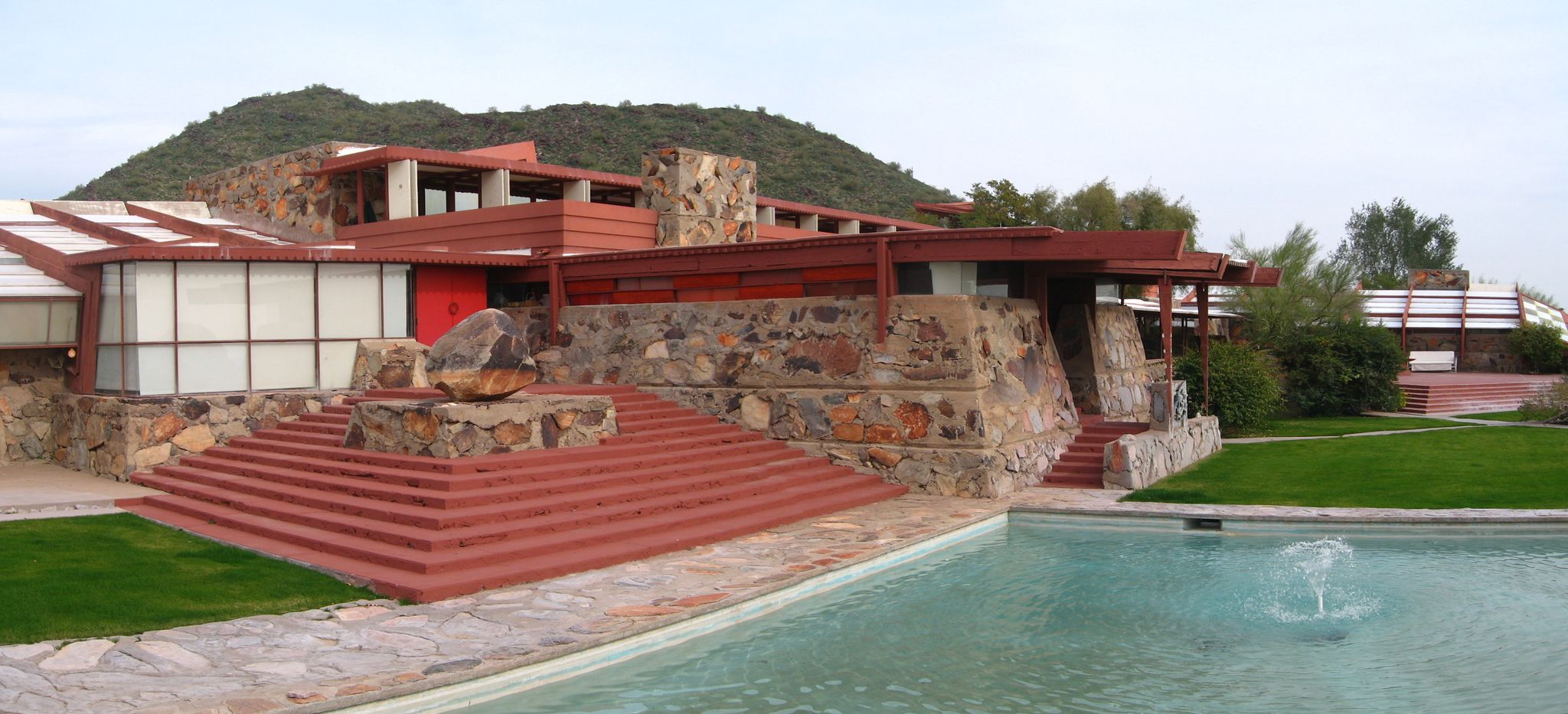 A large, multi-level building with a pool and distant hills. - McDowell Mountain loop