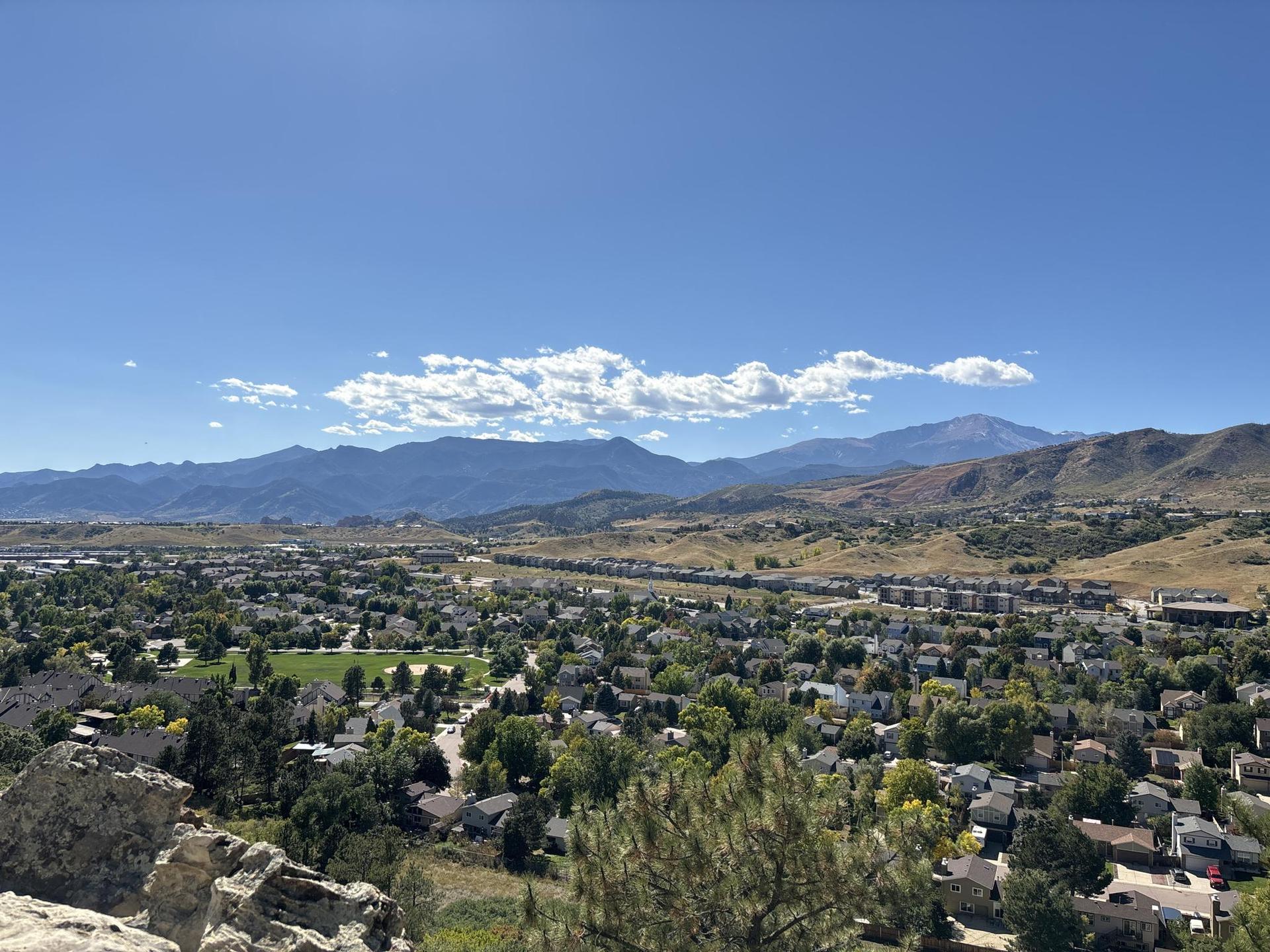Panoramic view of a town nestled in a valley with mountains beyond.