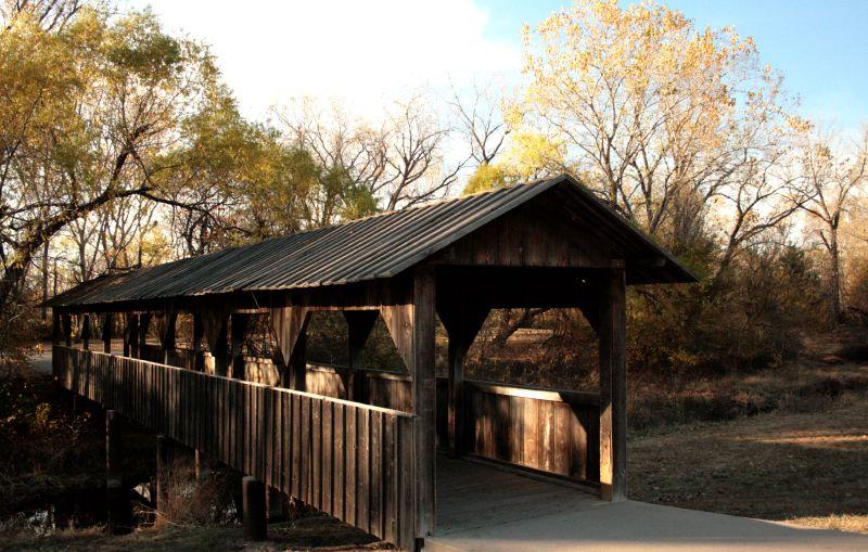 Long wooden covered bridge in an autumn landscape with bright natural light.