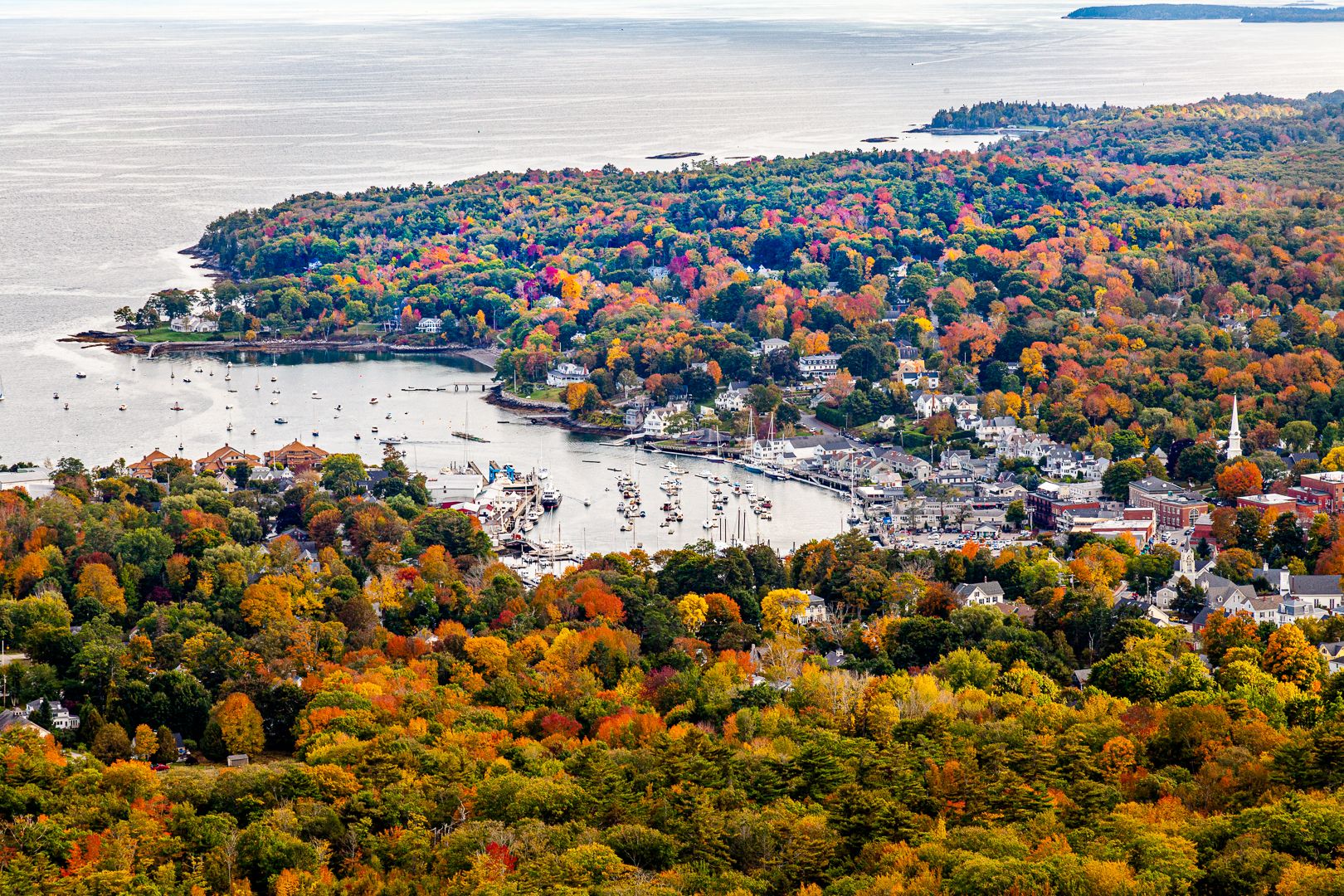Aerial view of a coastal town and harbor surrounded by vibrant autumn foliage. - Camden Hills State Park loop from Stevens Corner