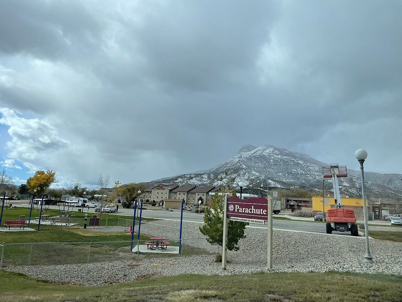 A cloudy sky over a snow-dusted mountain behind a small town park. - Rifle to Parachute loop