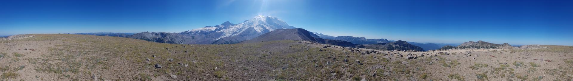 Panoramic view of a vast, rocky landscape with a distant snow-capped mountain.