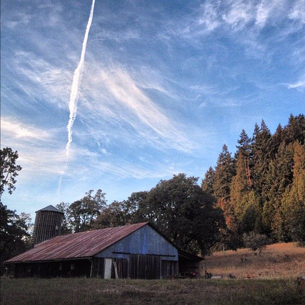 Old barn and silo under a dramatic blue sky with wispy clouds. - Mount Pisgah Summit Loop