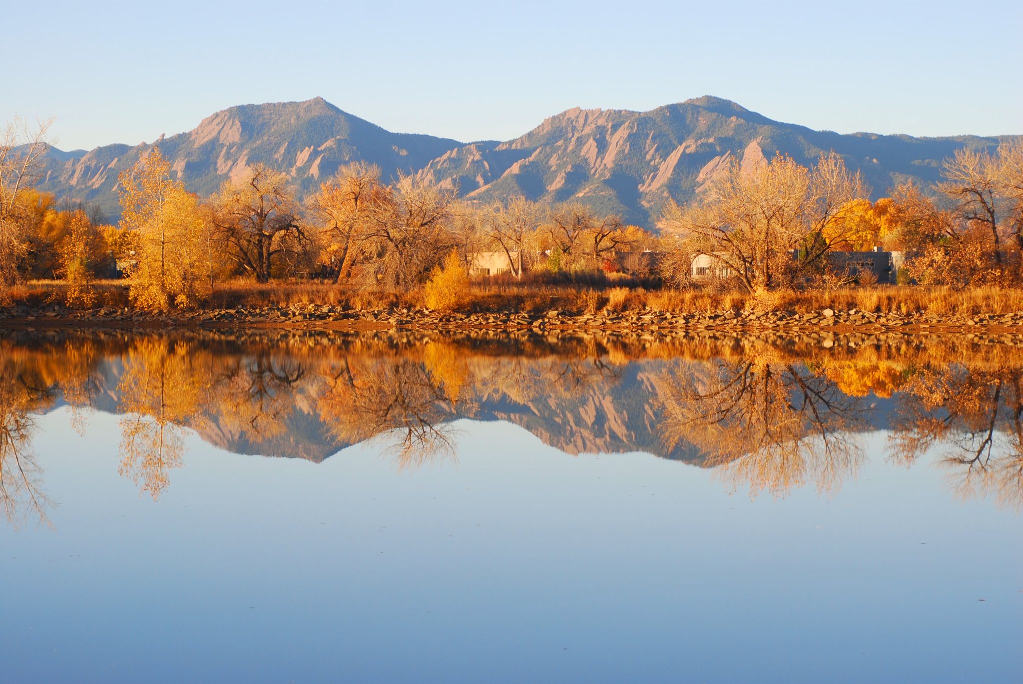 Golden autumn trees and mountains reflect perfectly in still water. - Twin Lakes Loop Trail