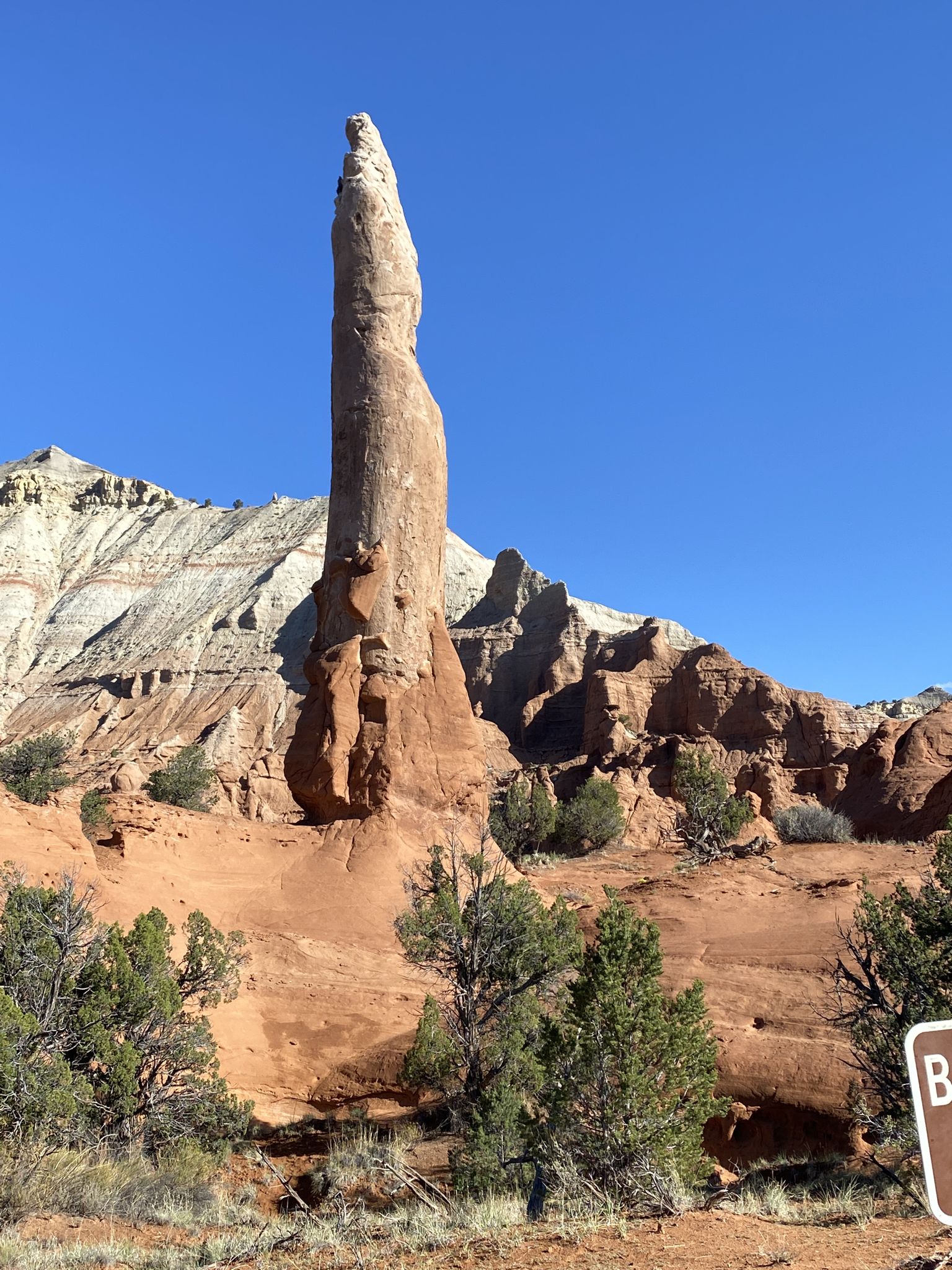 Tall, slender rock spire dominates a desert landscape under a clear blue sky. - Ballerina Spire – Panorama Point loop from Kodachrome Basin State Park