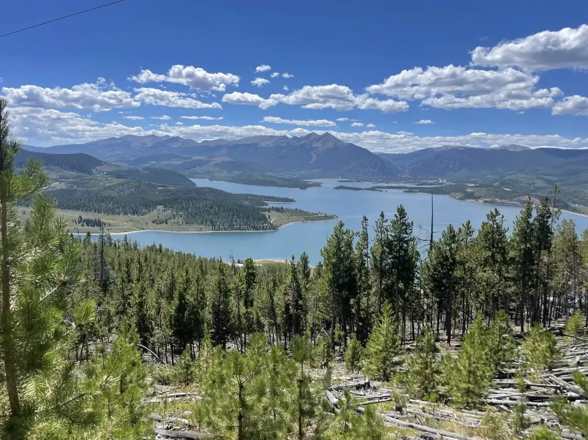 Panoramic view of a large blue lake surrounded by green forests and mountains. - Tenderfoot Mountain and Oro Grande Loop