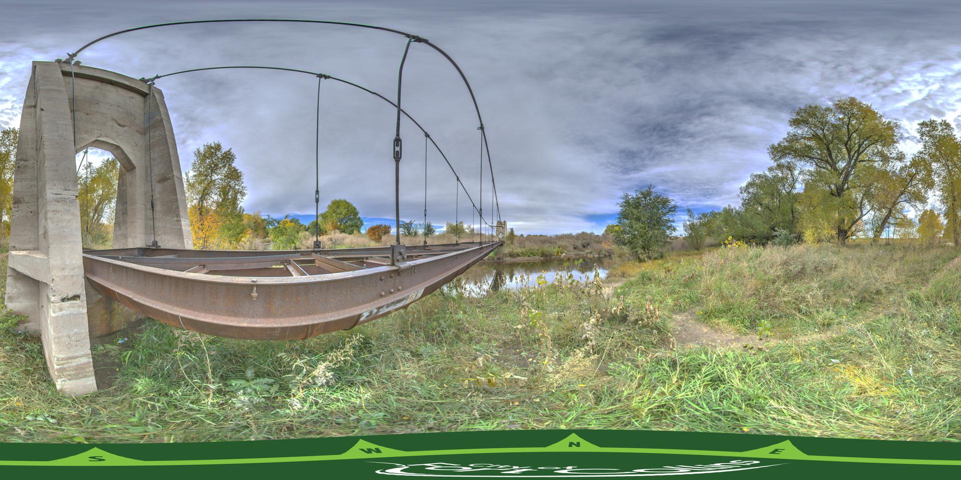 Panoramic view of a unique arched bridge over water, surrounded by autumn trees.