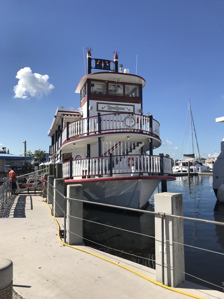 Large white paddleboat docked at a pier on a bright sunny day.