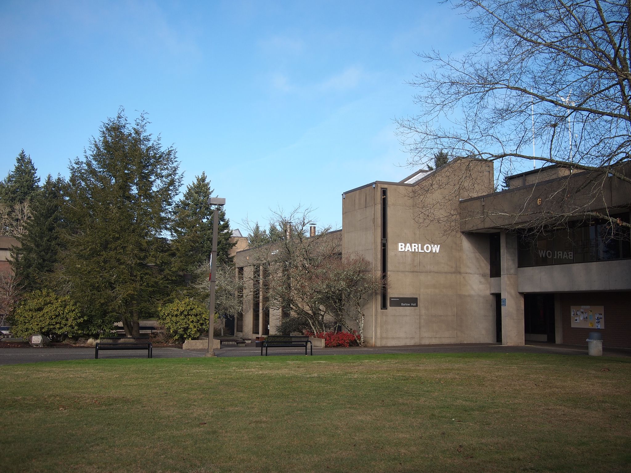 Concrete building with "BARLOW" sign, green lawn, and evergreen trees under clear sky. - Clackamas Community College loop from Clackamas Community College - Oregon City