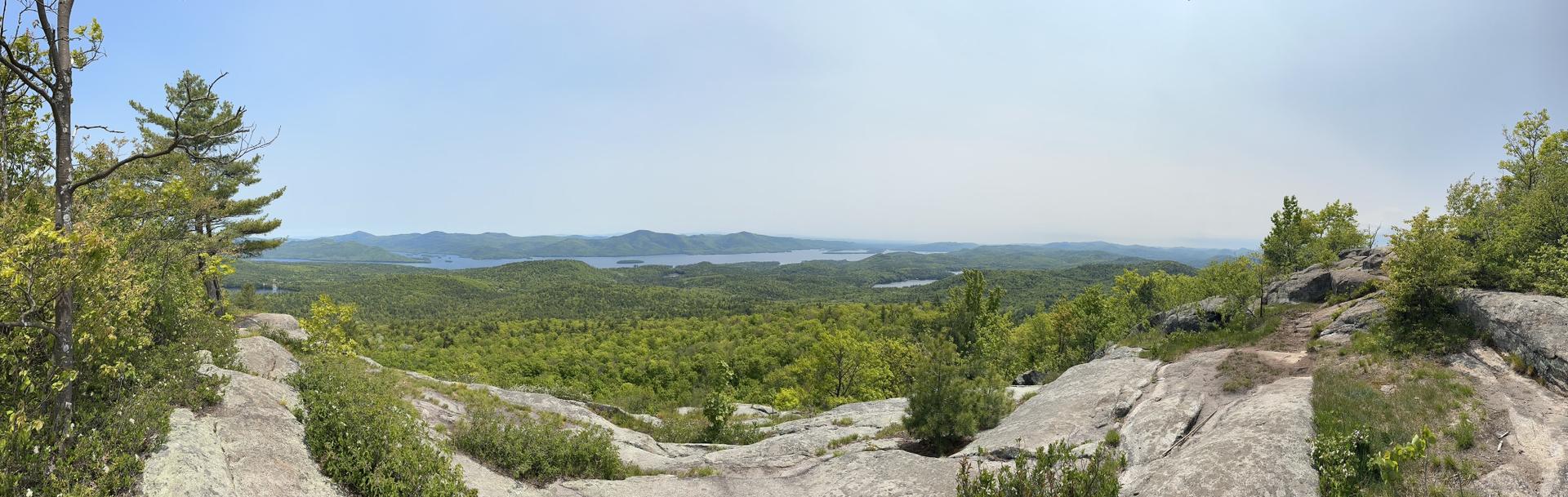 Panoramic view of a large lake surrounded by lush green forests.