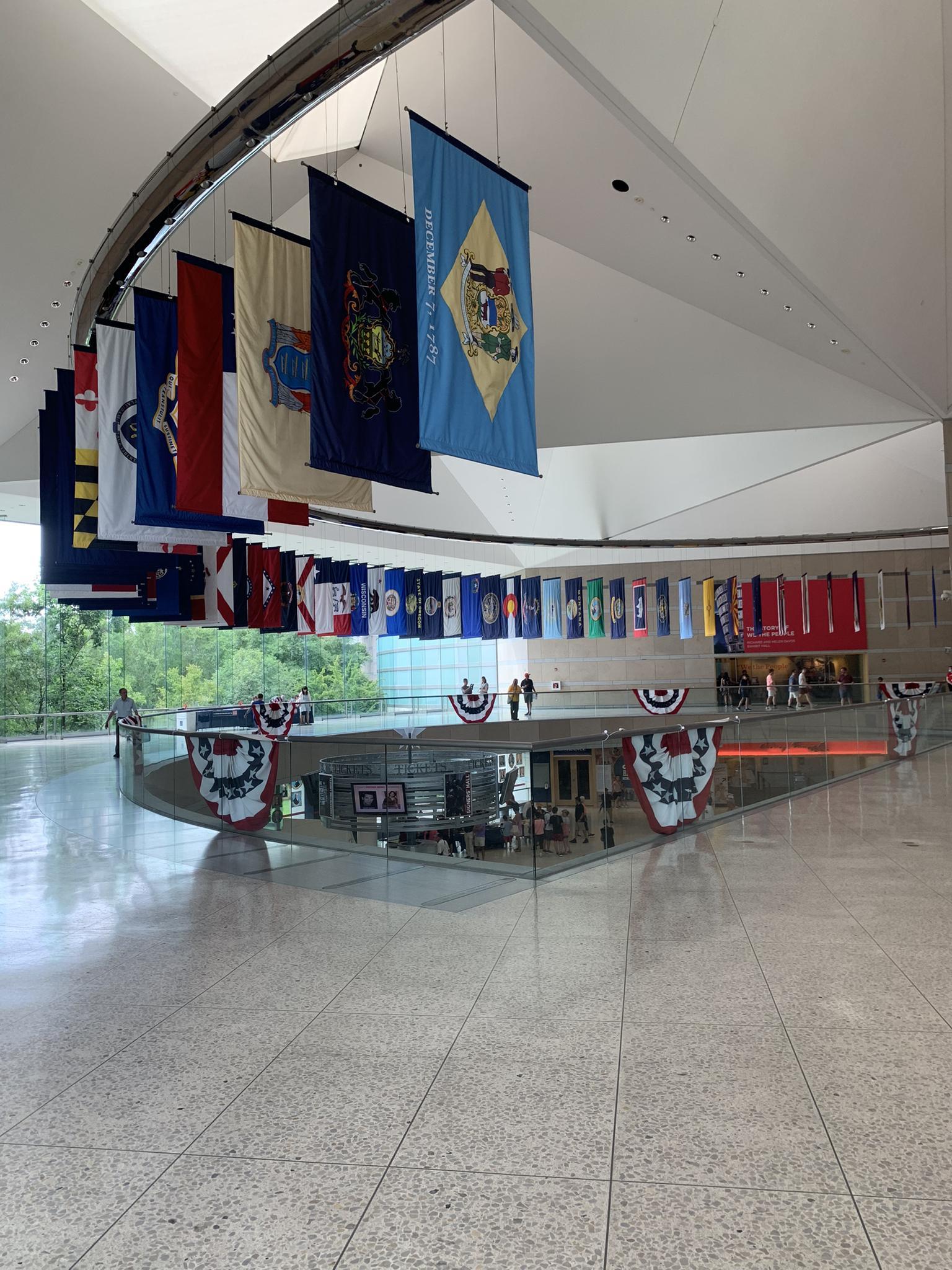 Spacious modern interior with many colorful flags hanging from a high ceiling.