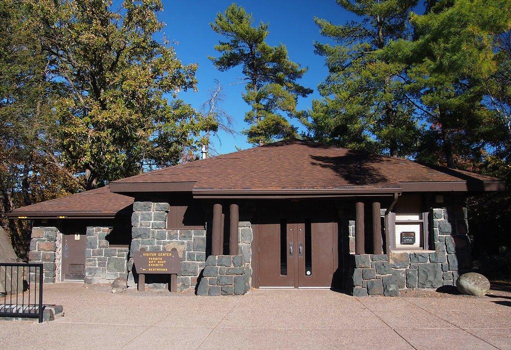 Stone and wood building with a brown roof under a clear blue sky.